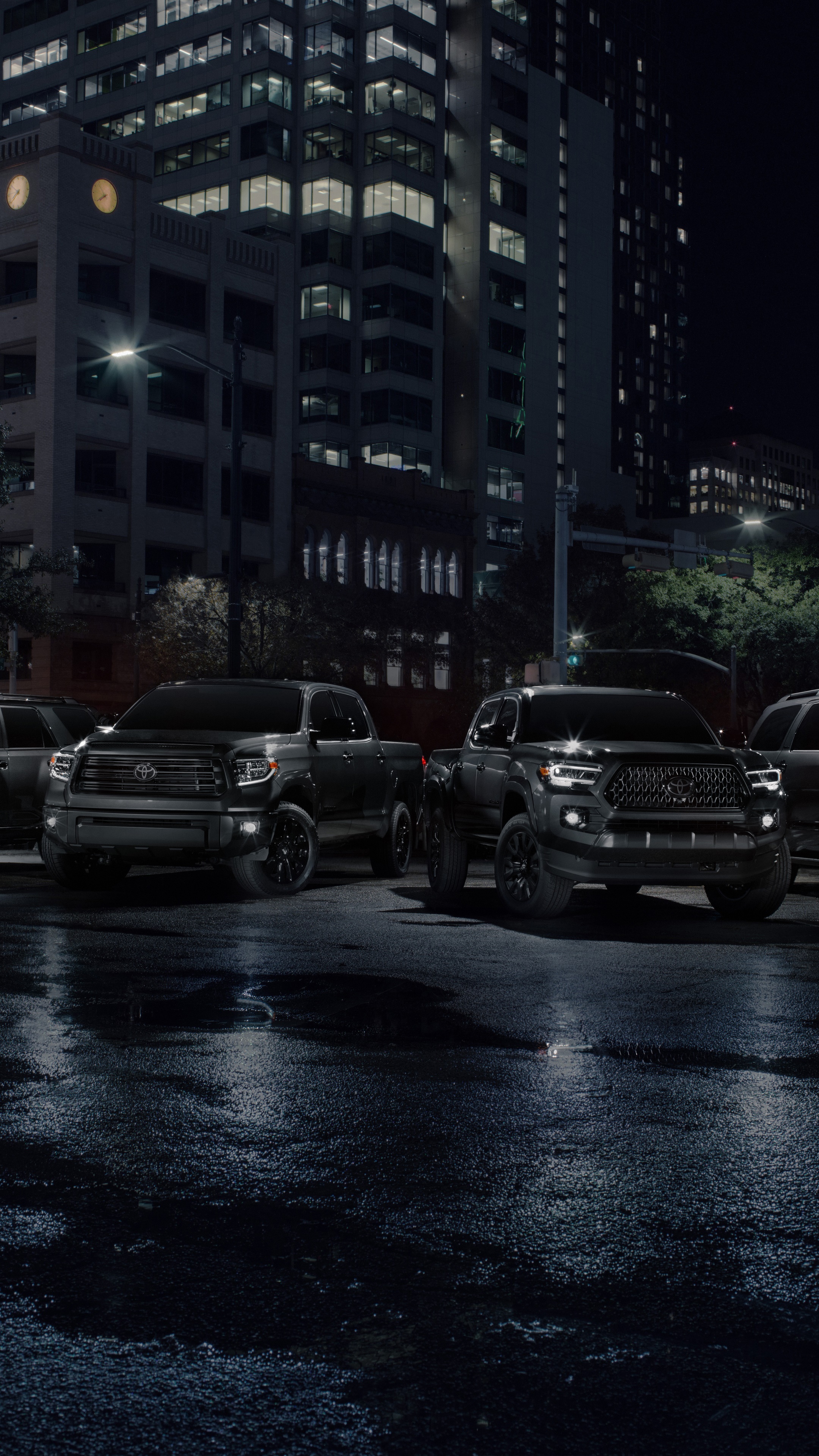 Toyota trucks parked on wet city street at night HD Phone Wallpaper