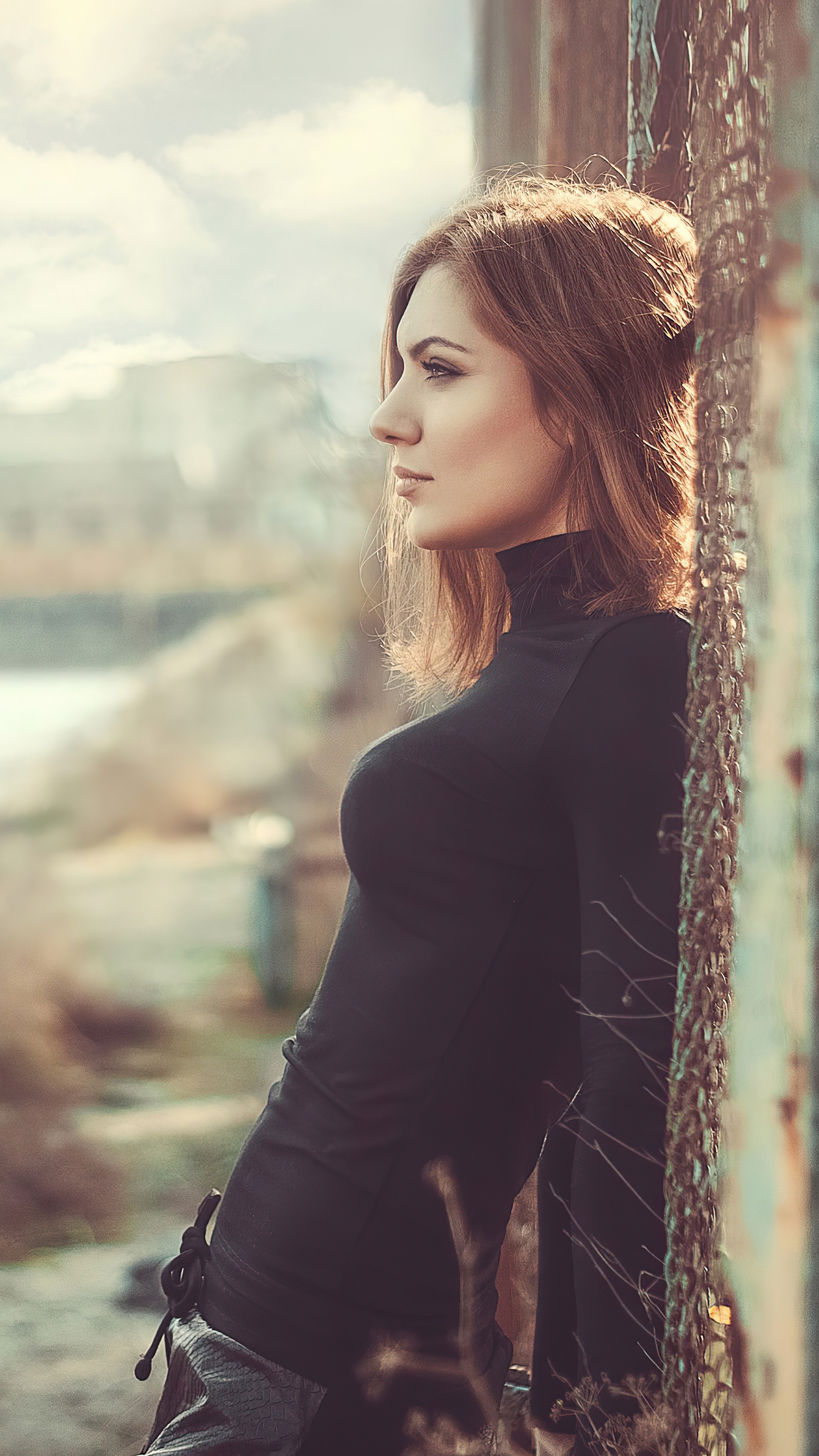 Girl in black turtleneck dress leaning against fence HD Phone Wallpaper
