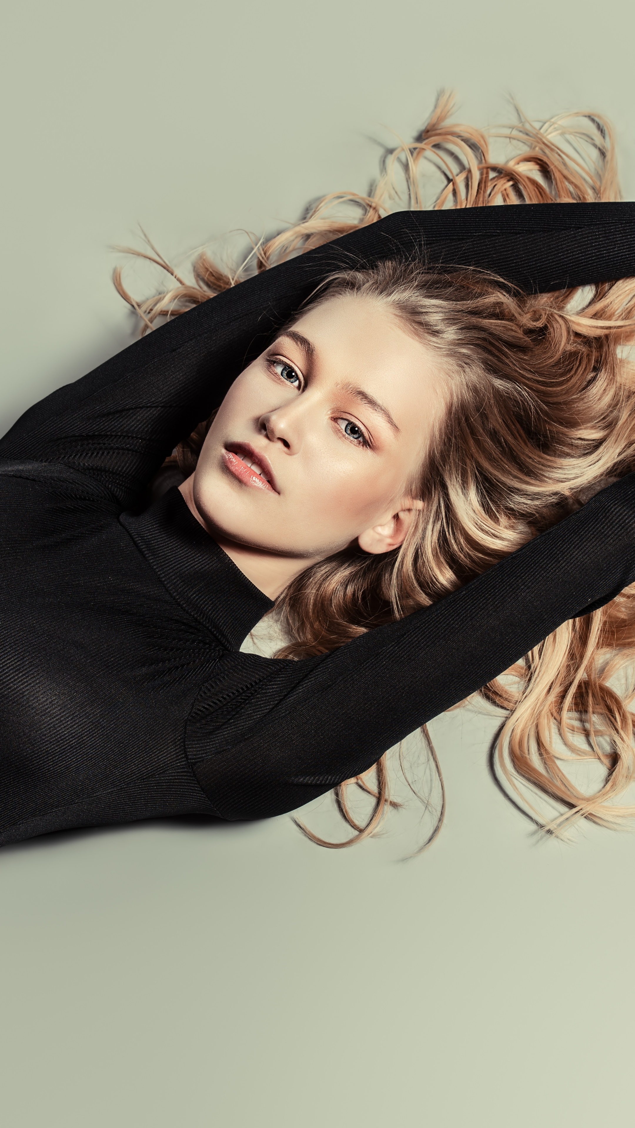 Blonde model lying down wearing black top HD Phone Wallpaper