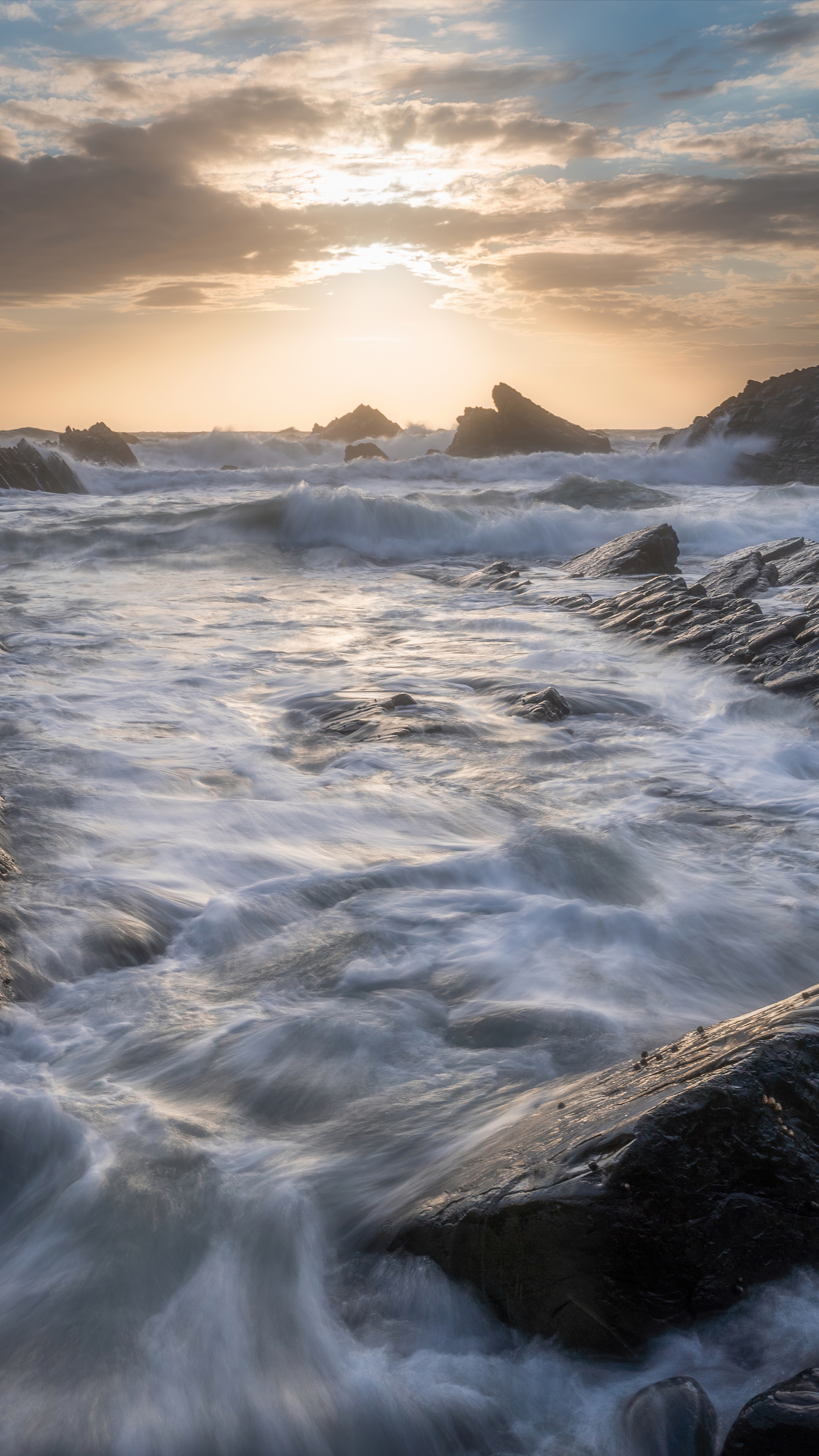 Waves crashing on rocky beach at sunset 4K HD Phone Wallpaper