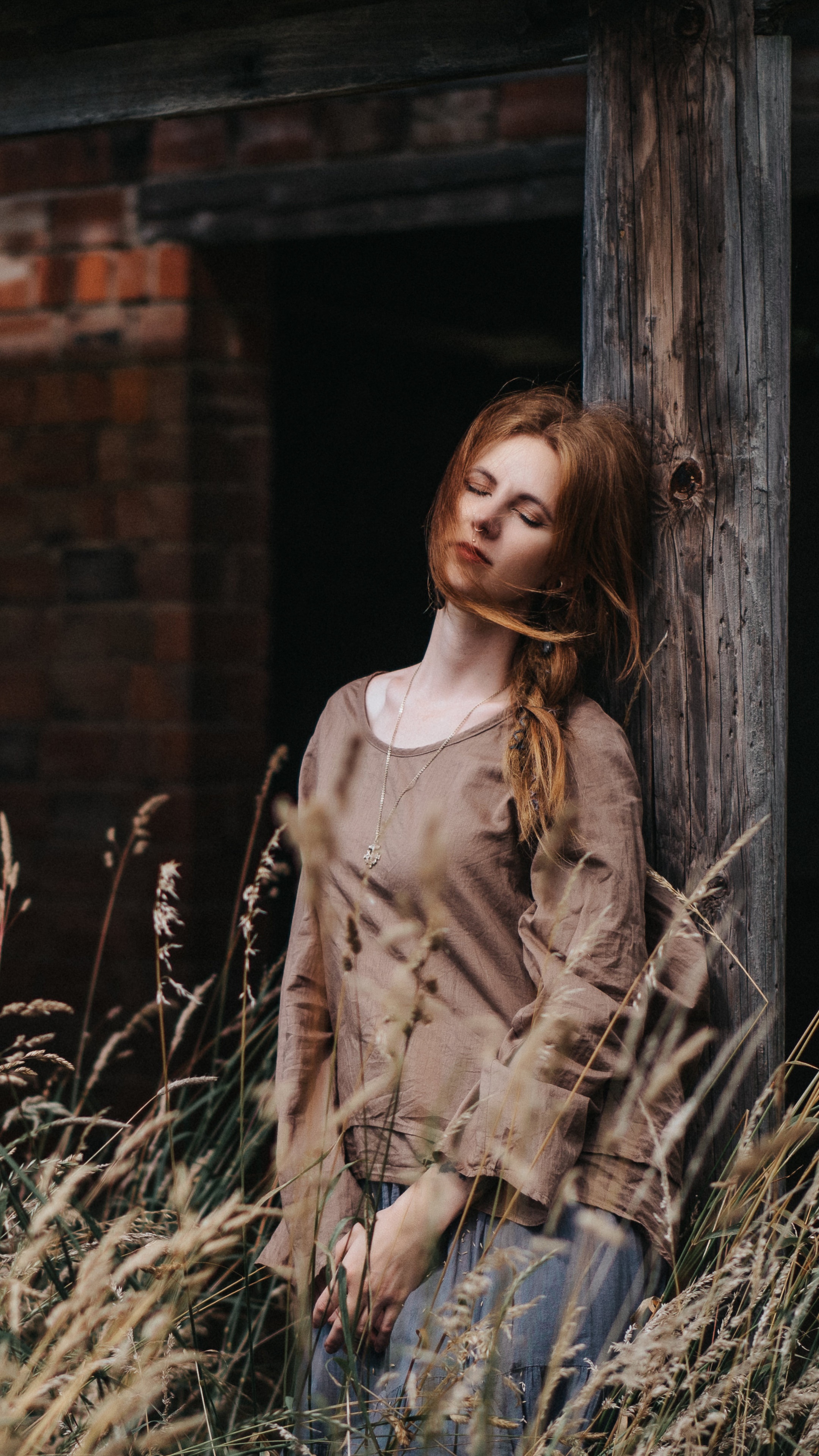 Red-haired girl leaning against a wooden post HD Phone Wallpaper