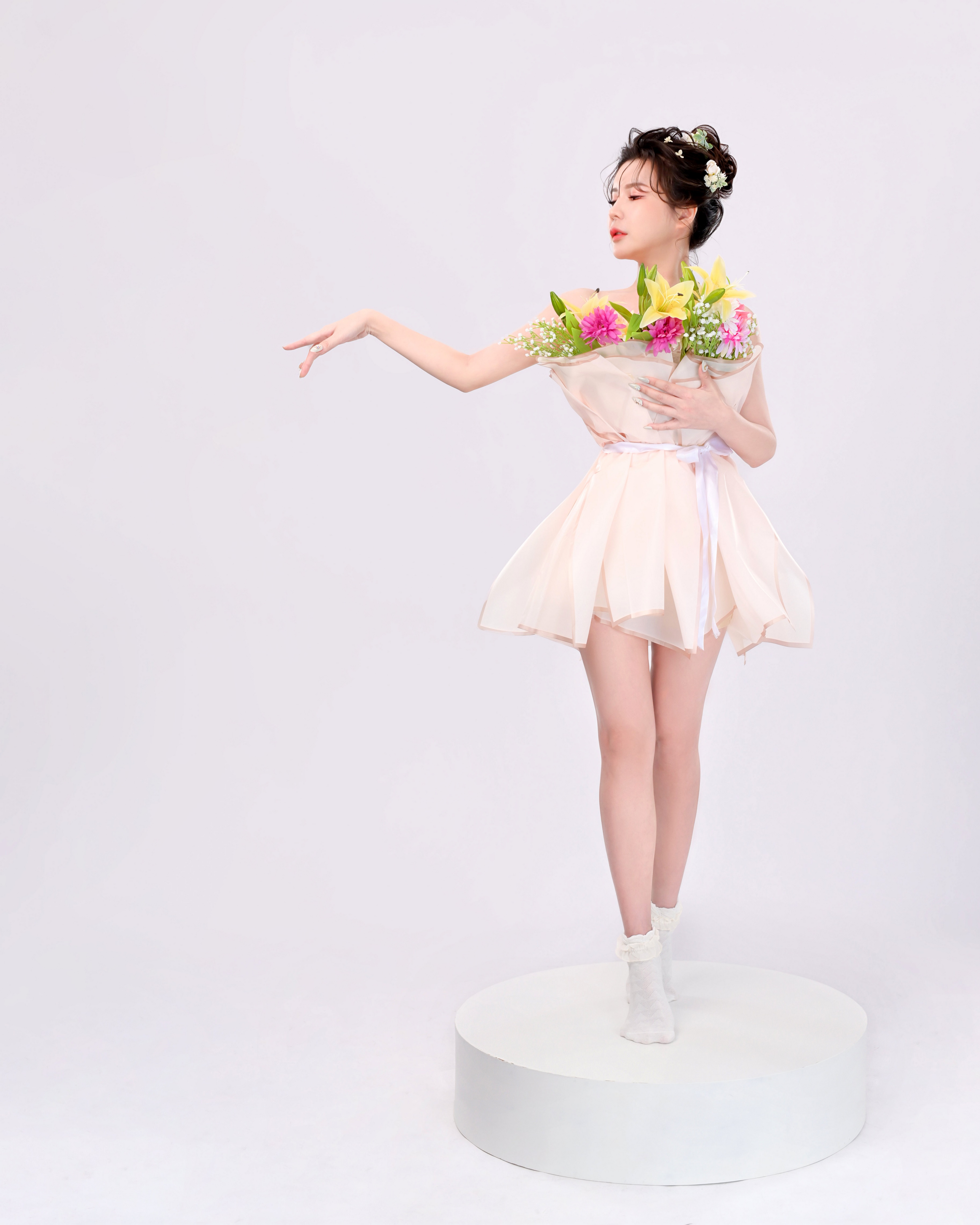 Asian woman in dress holding flowers on a white platform HD Phone Wallpaper