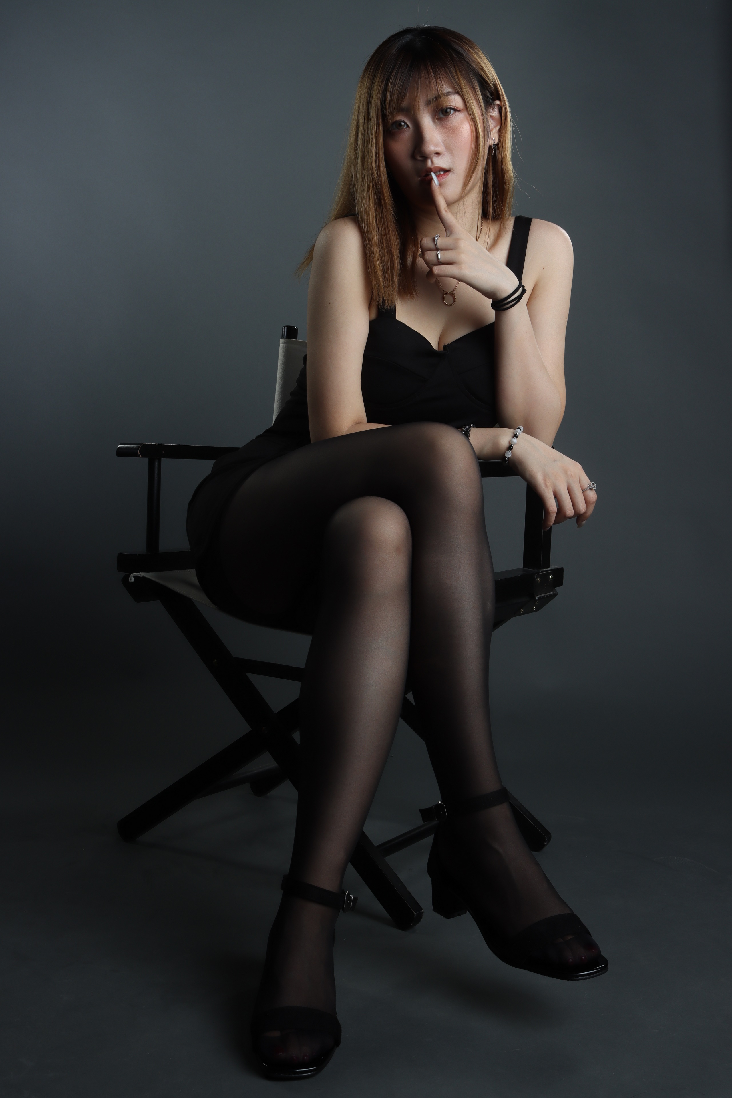 Woman in black dress and pantyhose sitting on chair HD Phone Wallpaper