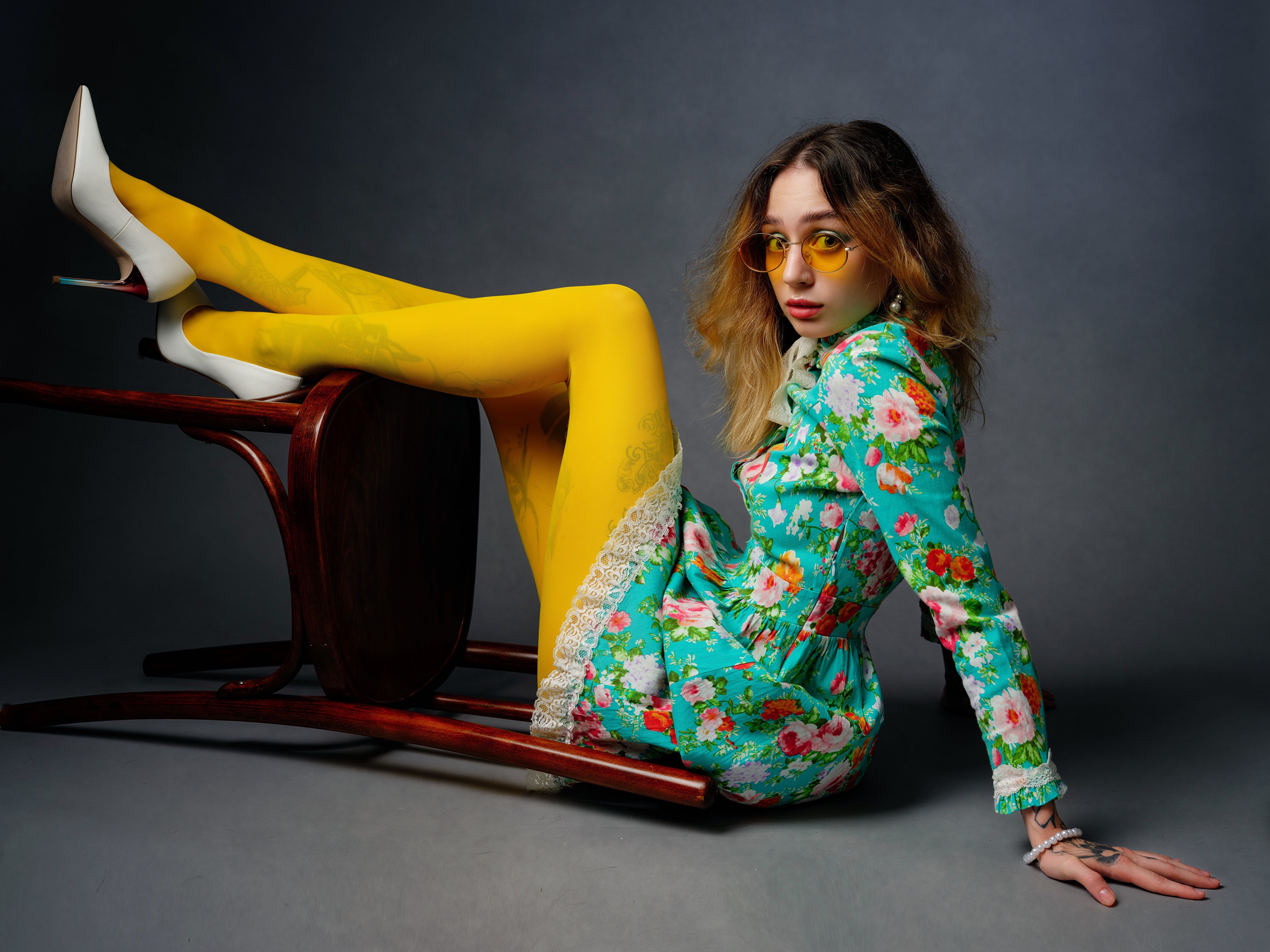 Woman in floral dress and yellow pantyhose posing on chair HD Wallpaper