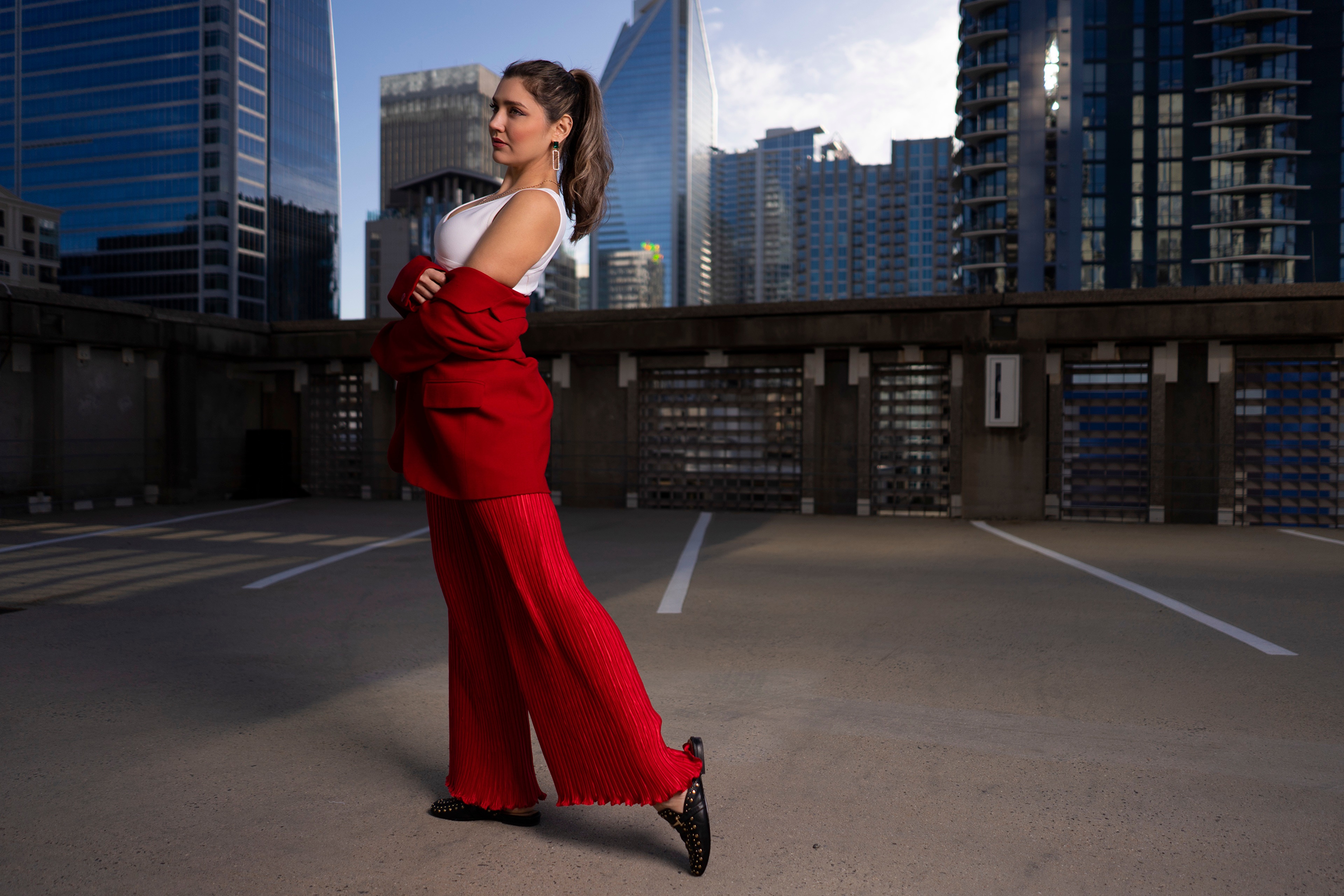 Woman in red suit jacket and trousers posing HD Wallpaper