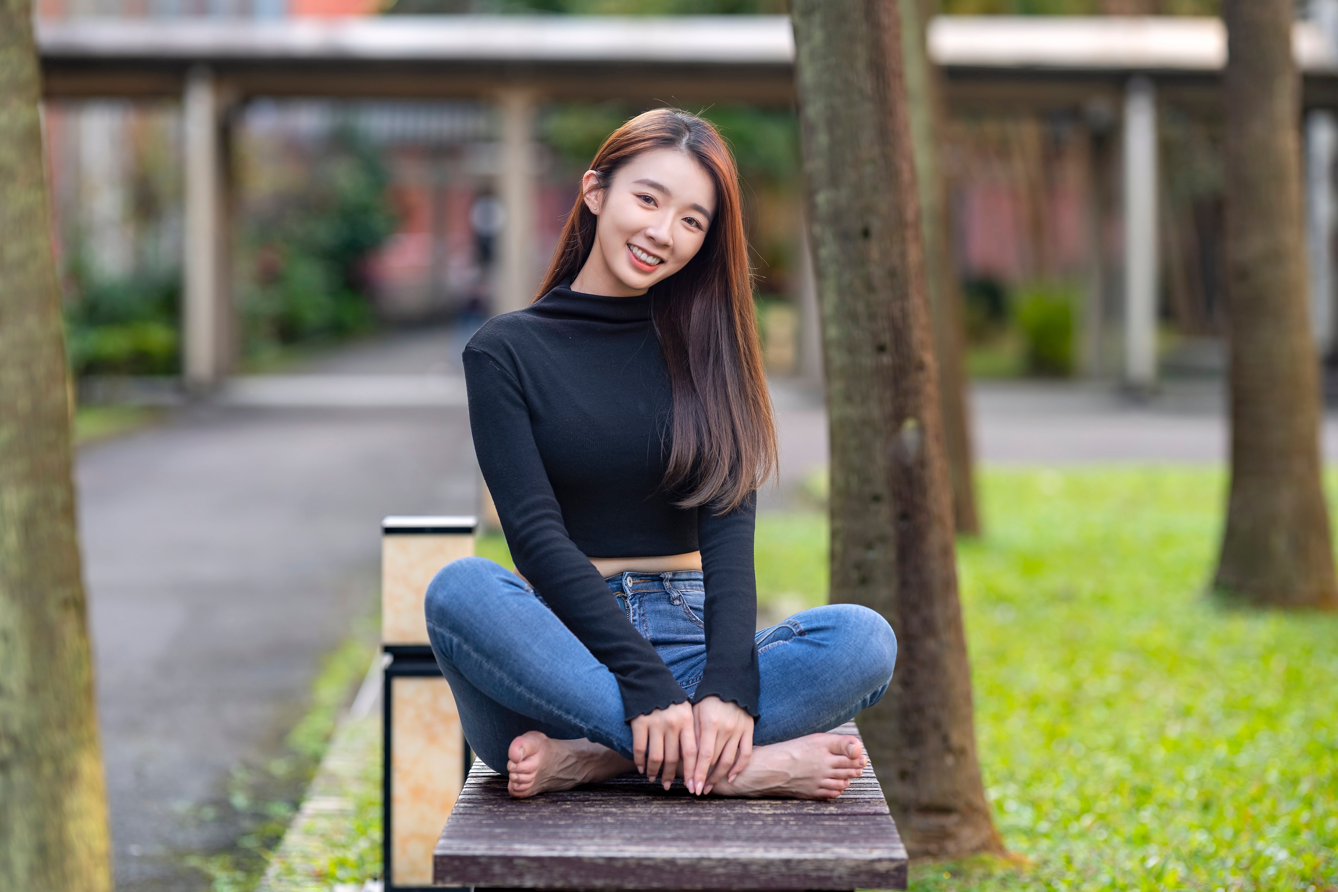 Woman in black blouse and jeans sitting on bench HD Wallpaper