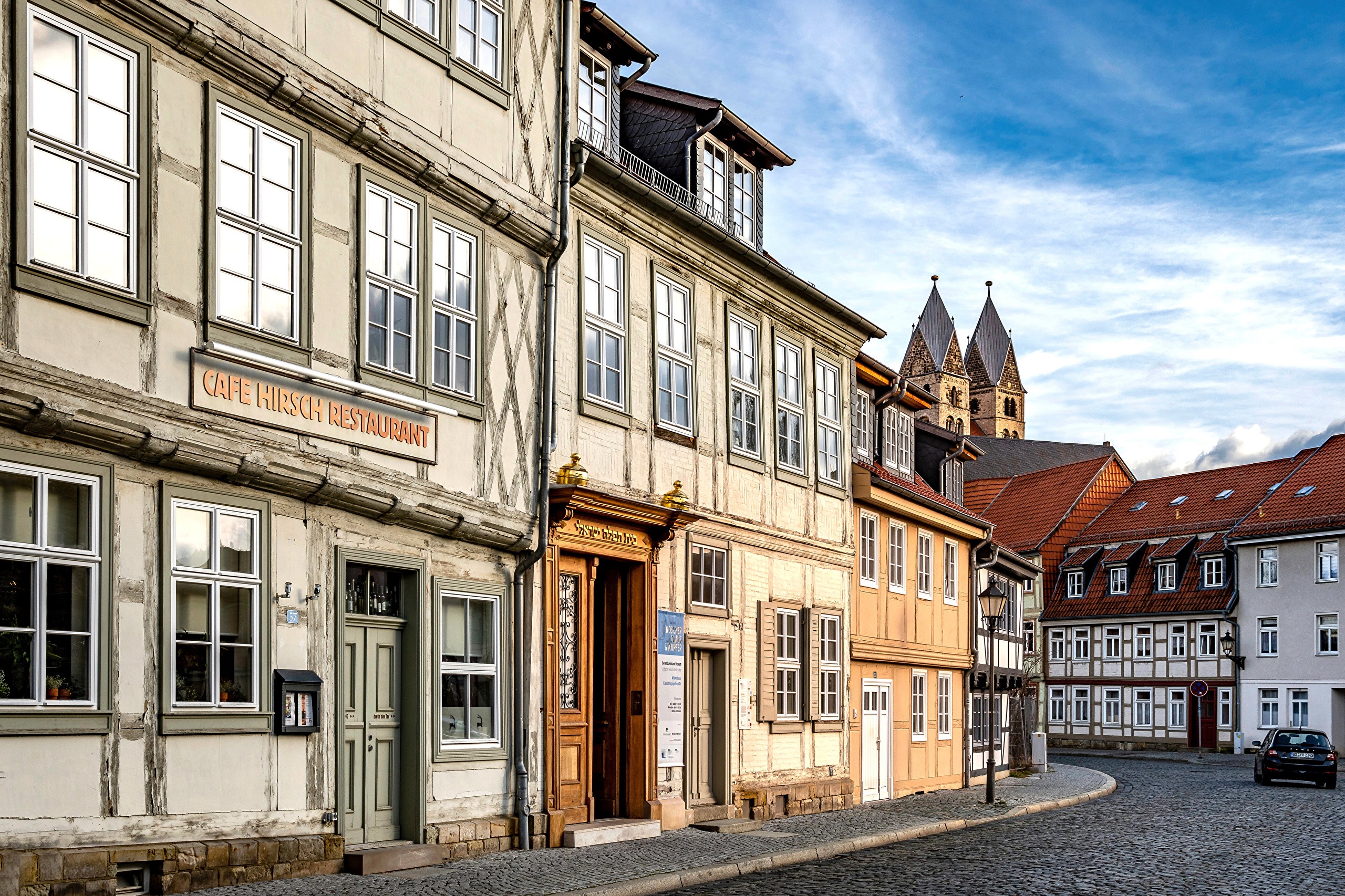 Halberstadt, Germany street with historic buildings and church towers HD Wallpaper
