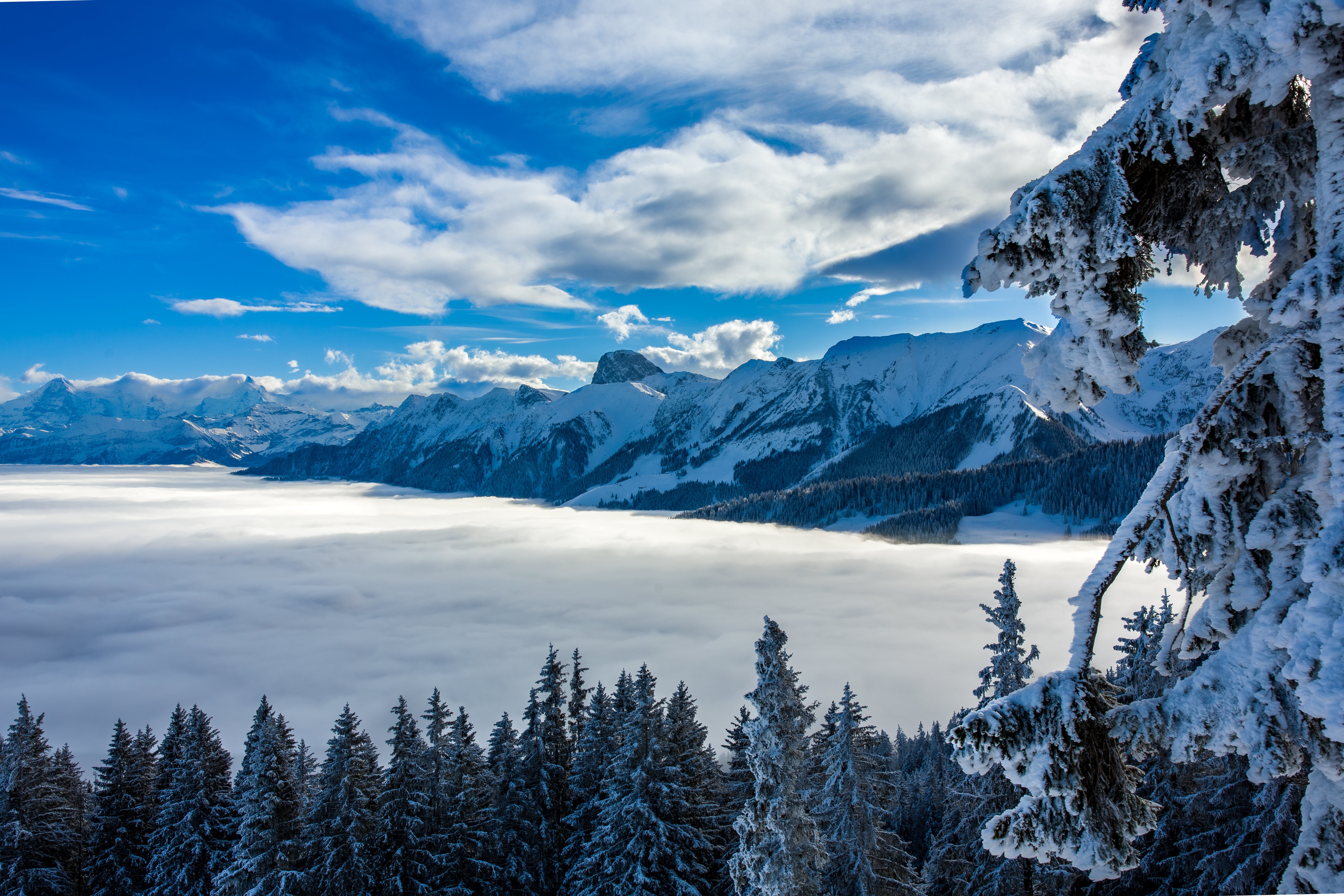Snowy mountains above clouds in Switzerland HD Wallpaper