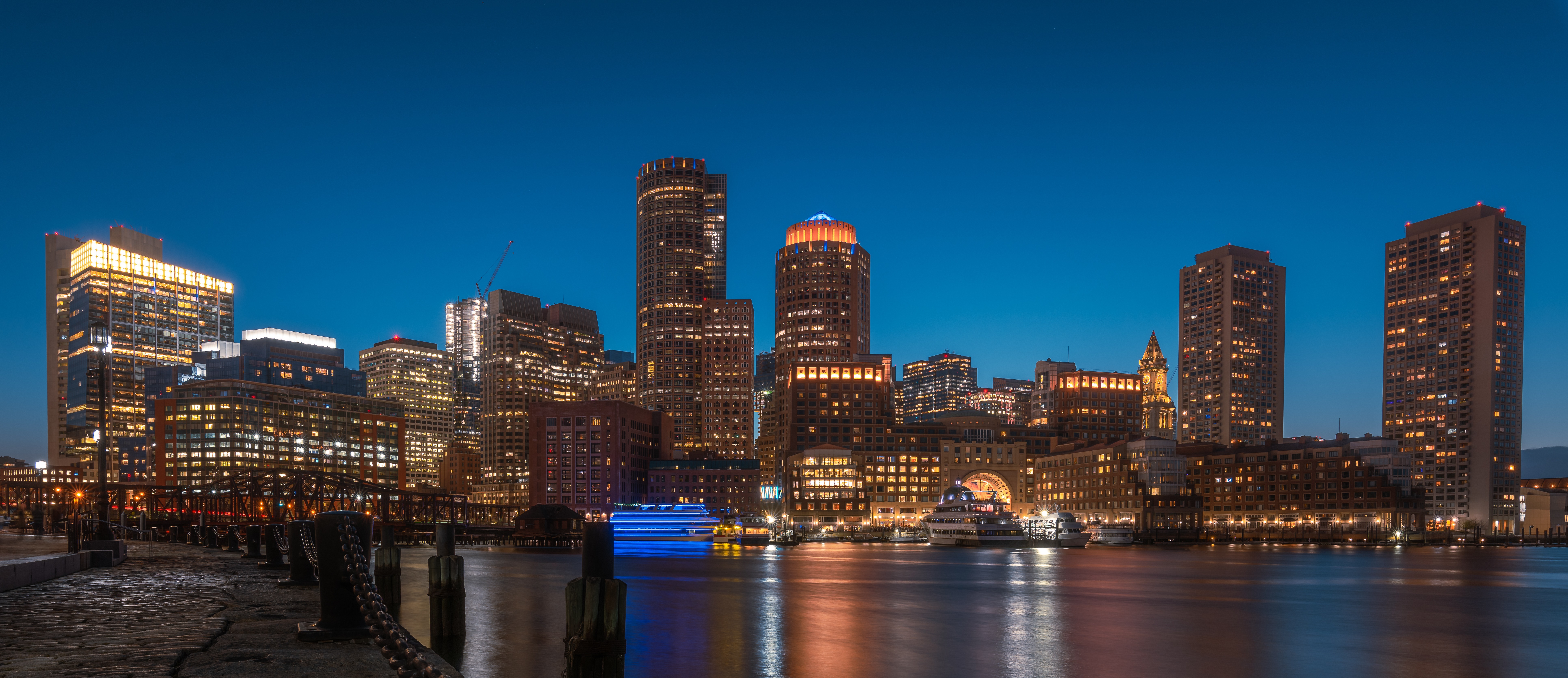 Boston skyline at night with river and boats HD Wallpaper