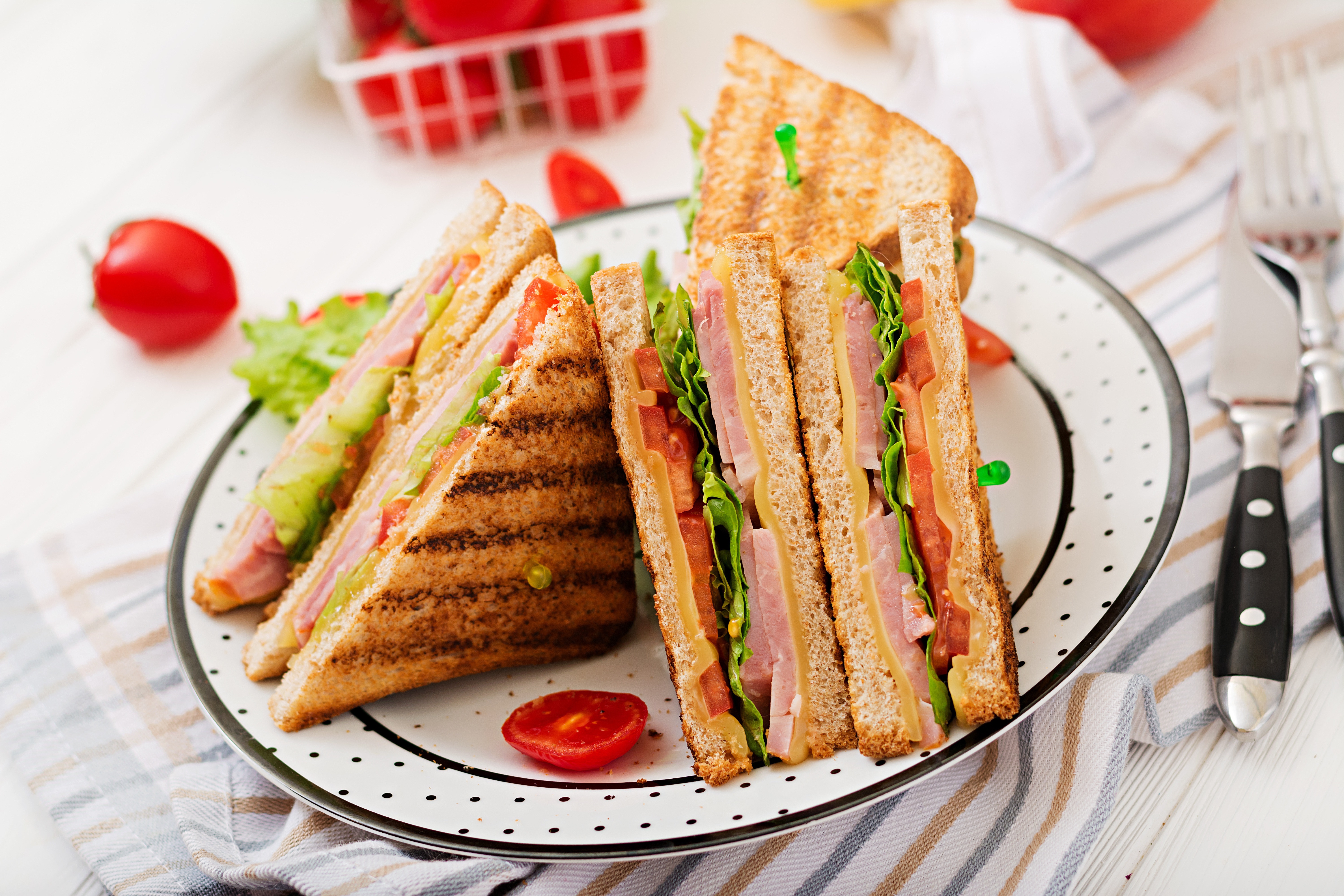 Sandwiches on a plate with tomatoes and cutlery HD Wallpaper