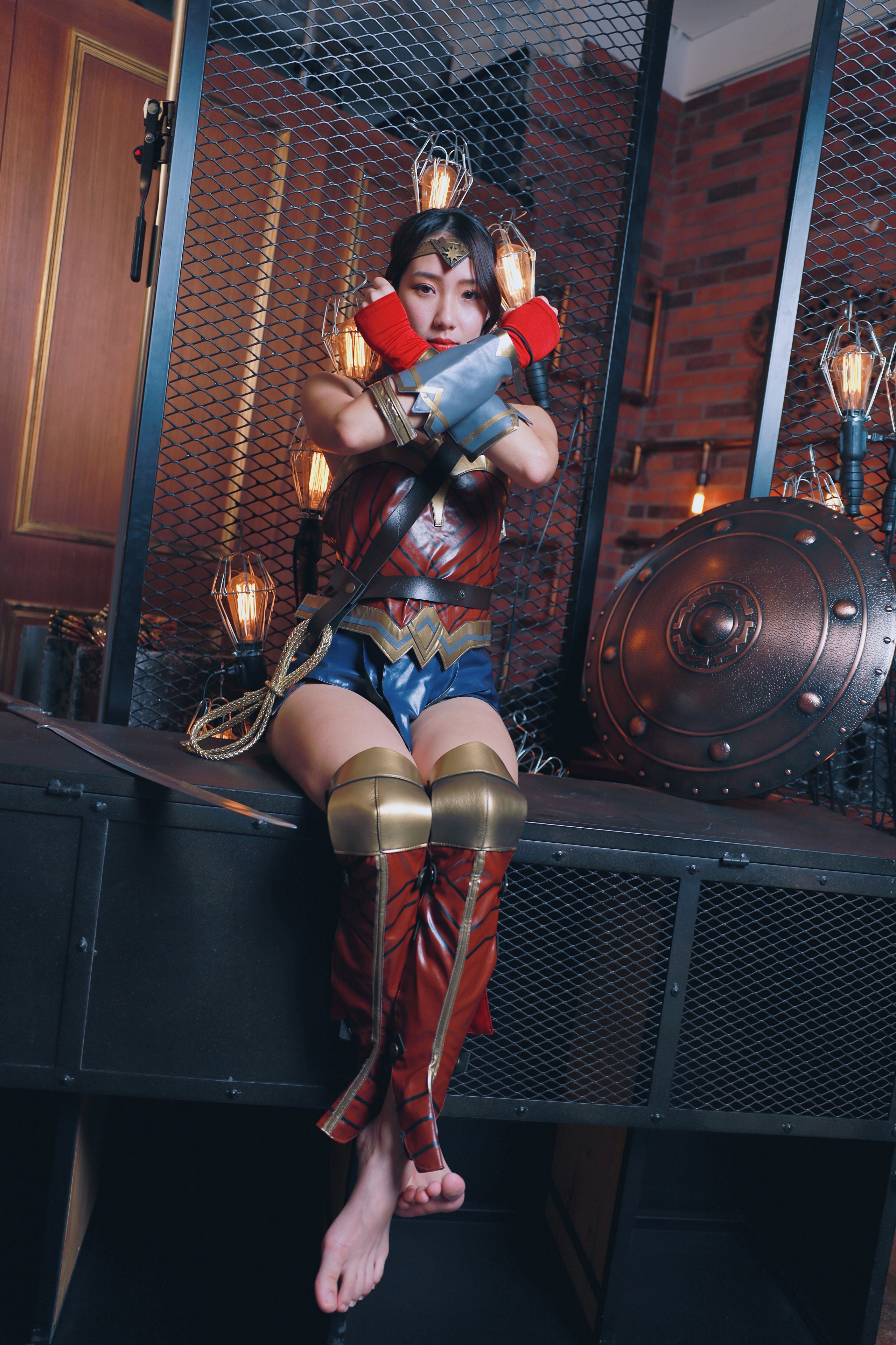 Asian woman in Wonder Woman cosplay sitting with shield HD Phone Wallpaper