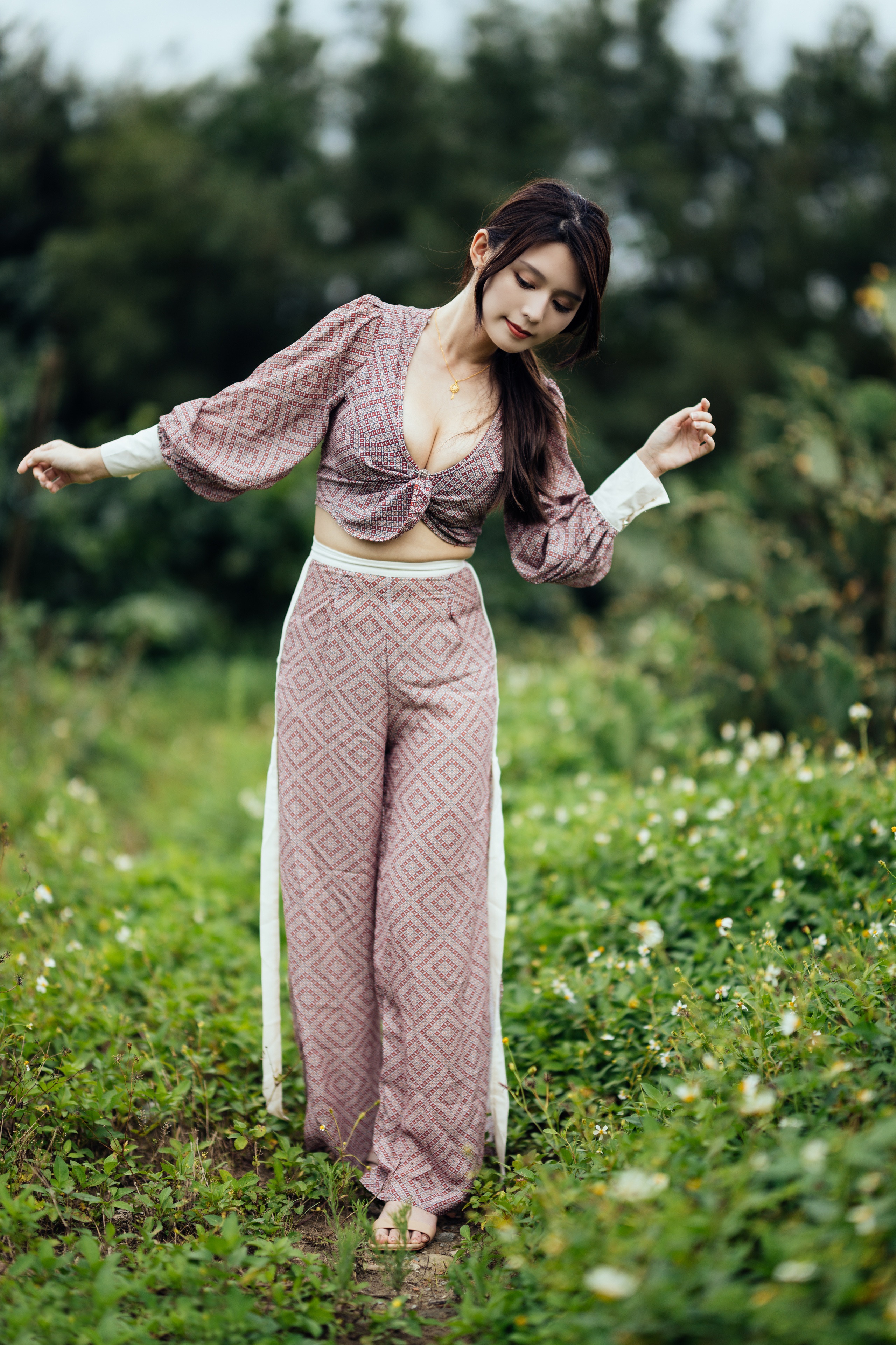 Asian woman in patterned blouse and trousers outdoors HD Phone Wallpaper