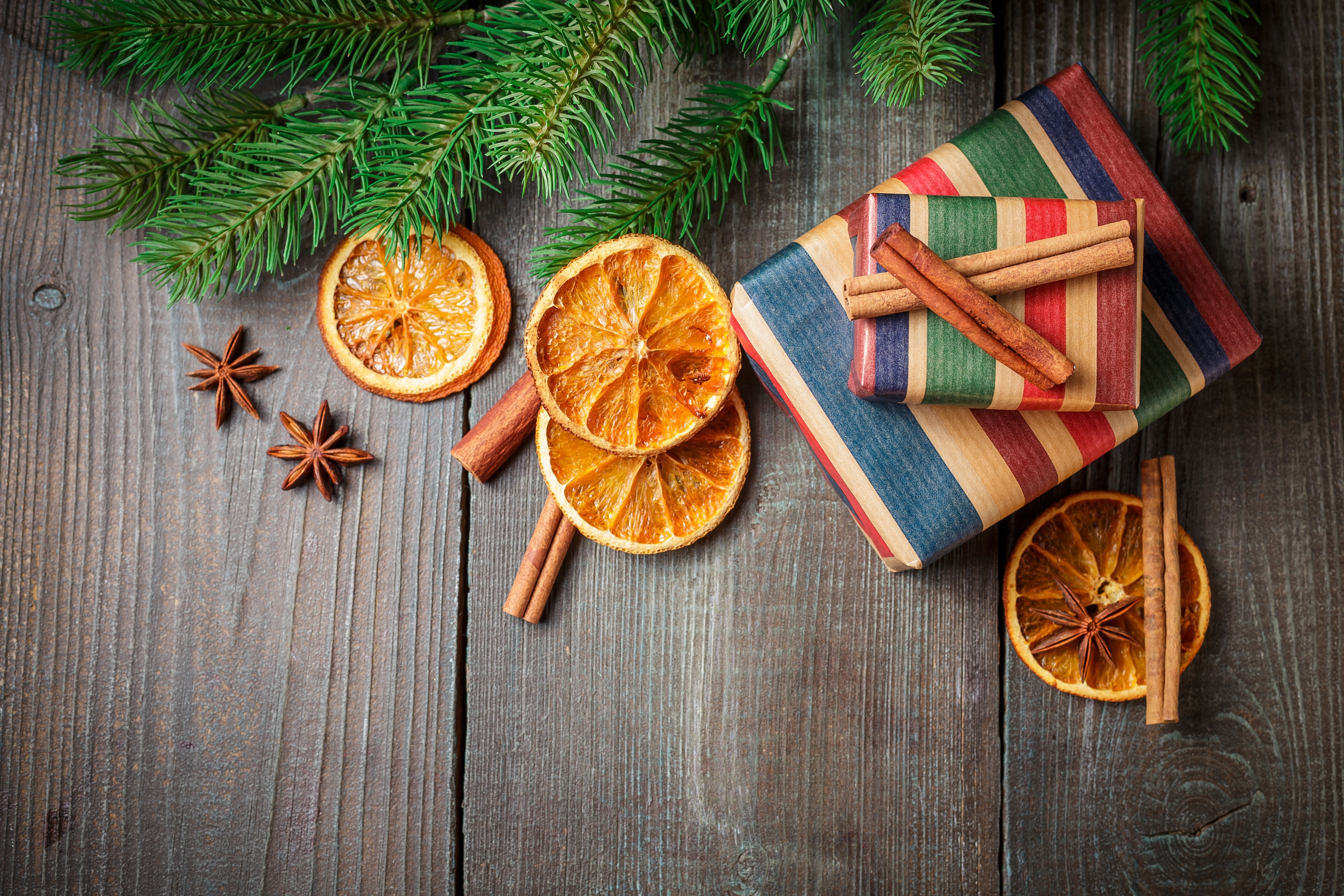 Christmas gifts with dried oranges and cinnamon on wood HD Wallpaper