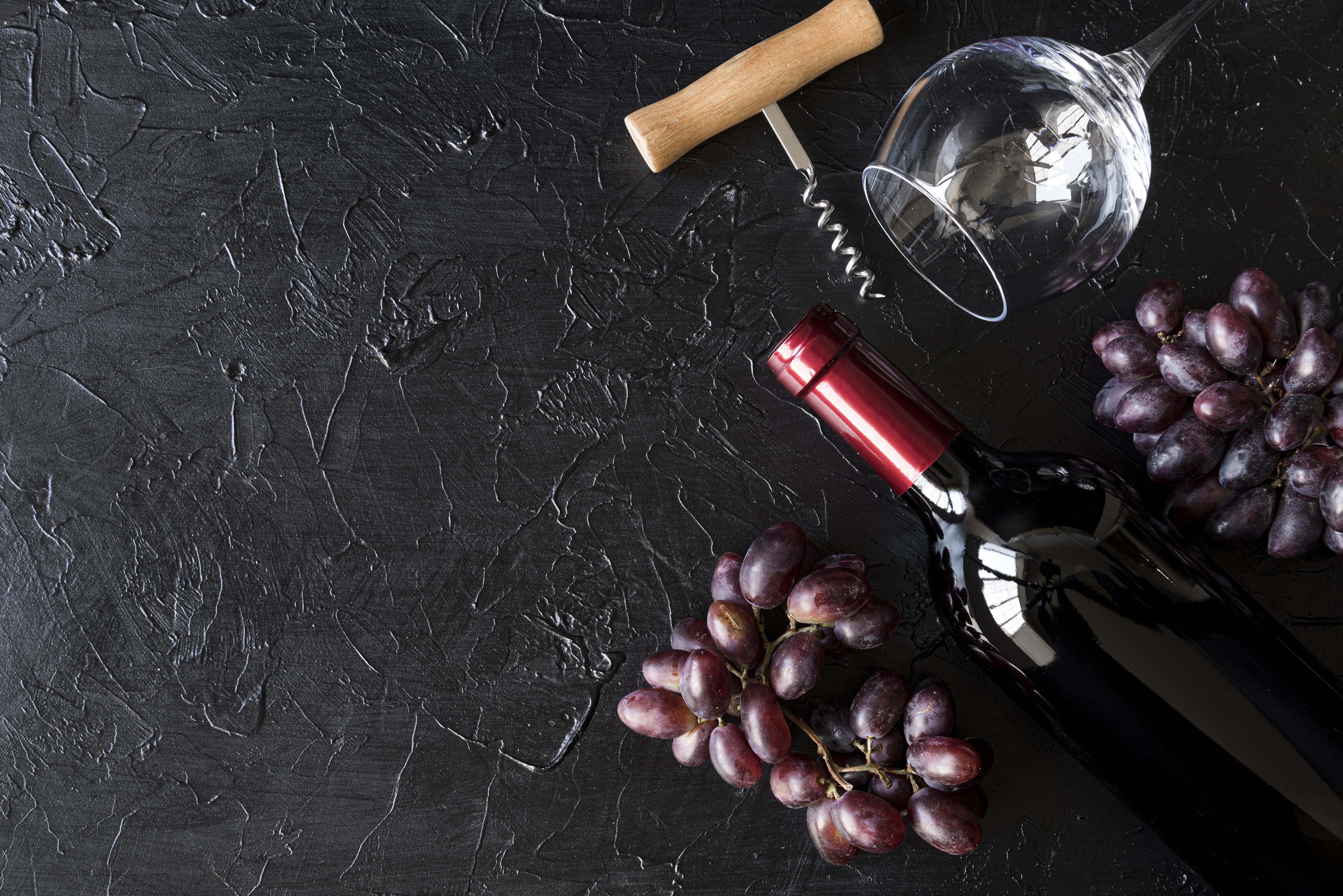 Grapes, Wine Bottle, Wine Glass, and Corkscrew on Black Surface HD Wallpaper