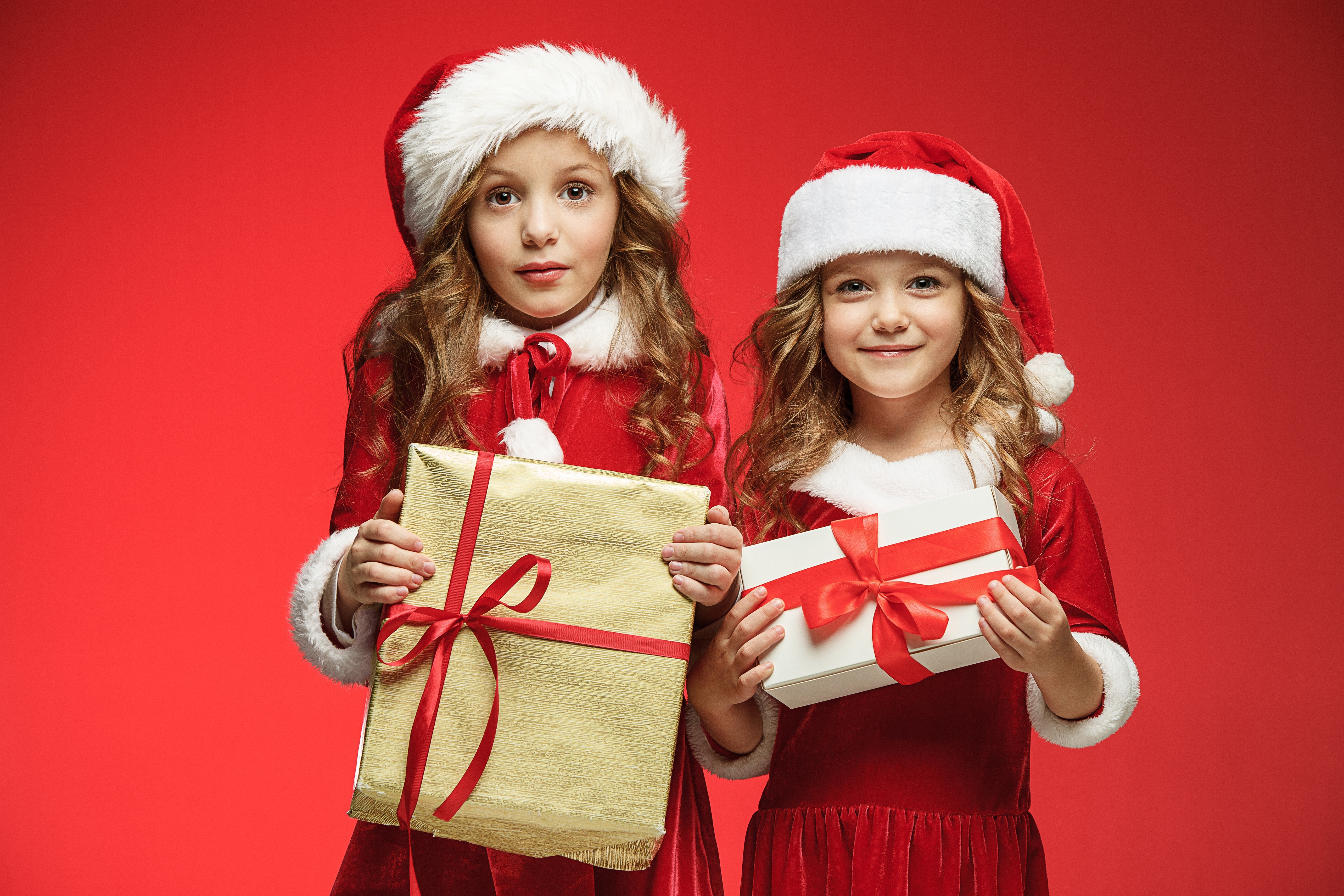 Two girls in Santa costumes with Christmas gifts HD Wallpaper