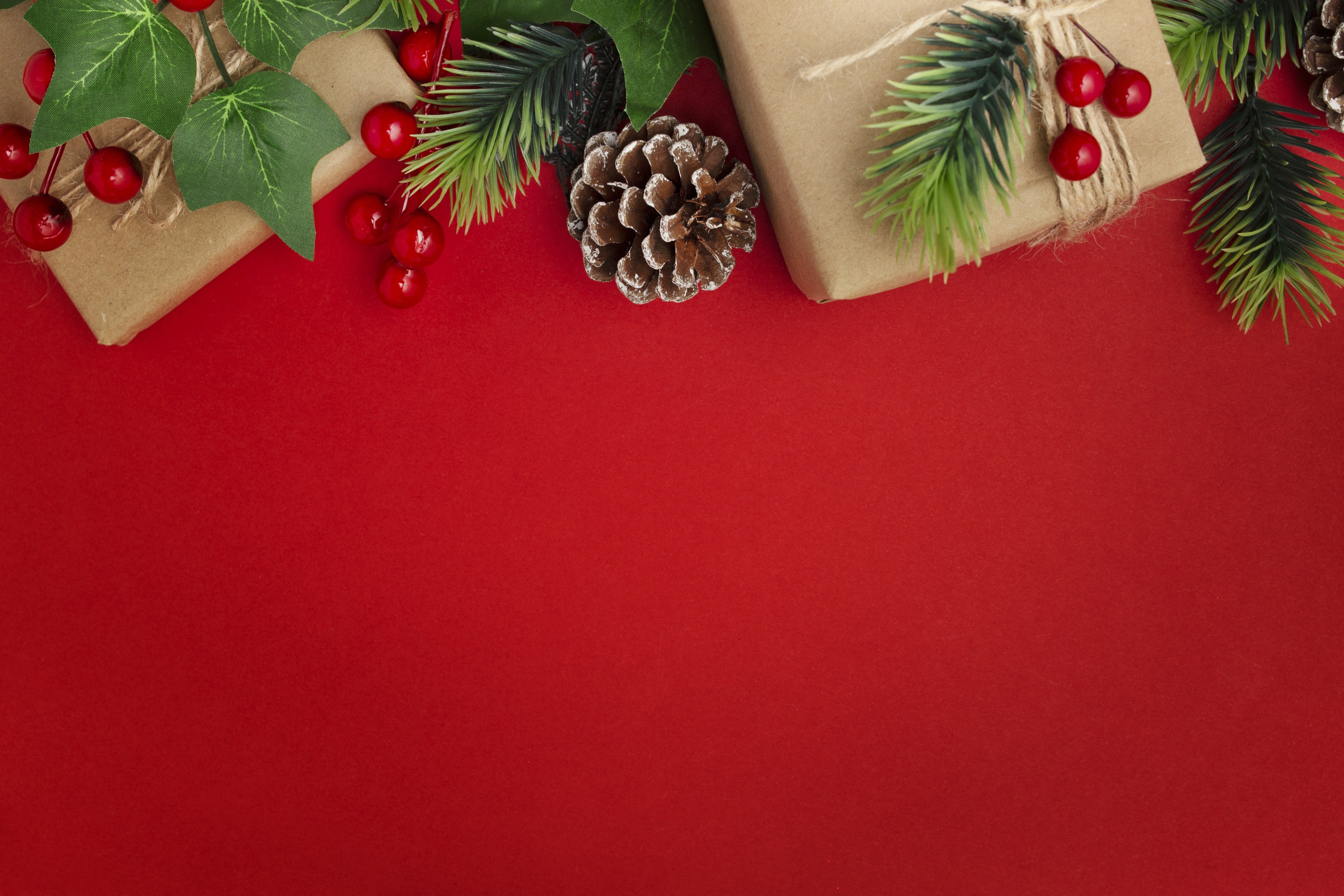 Christmas gifts with pine cones and branches on red background HD Wallpaper