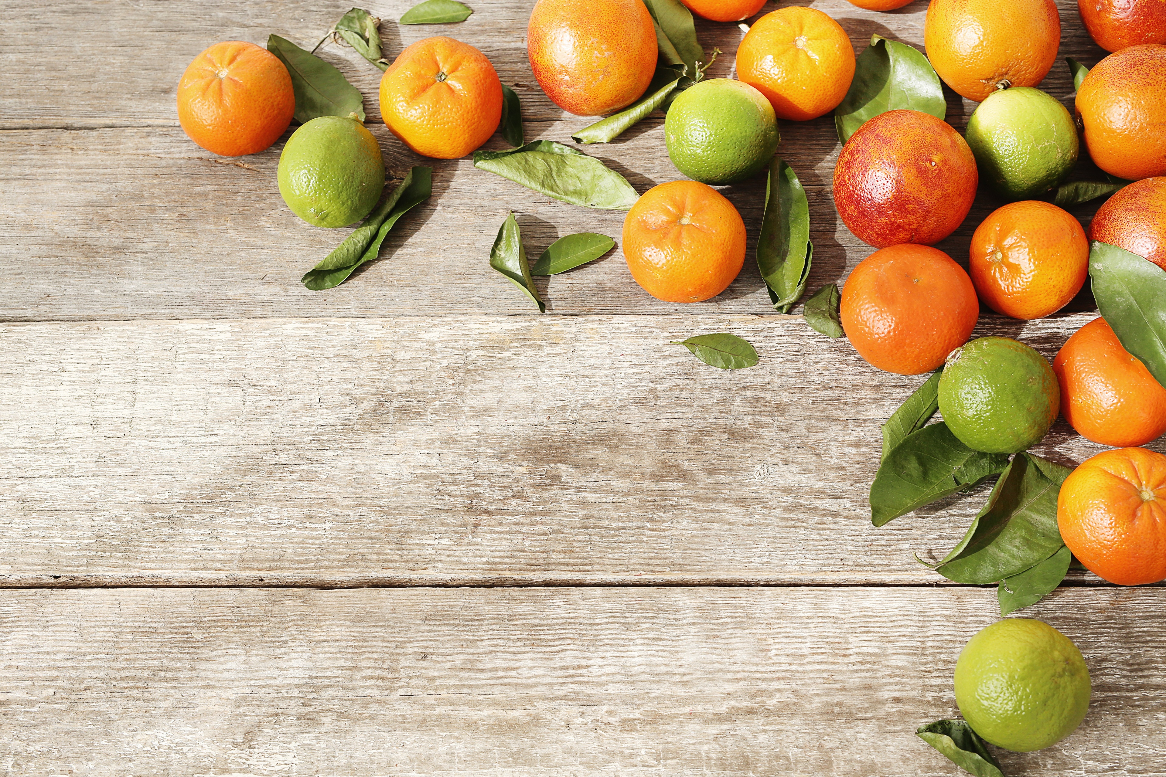 Oranges, Limes, and Leaves on Wood Planks HD Wallpaper