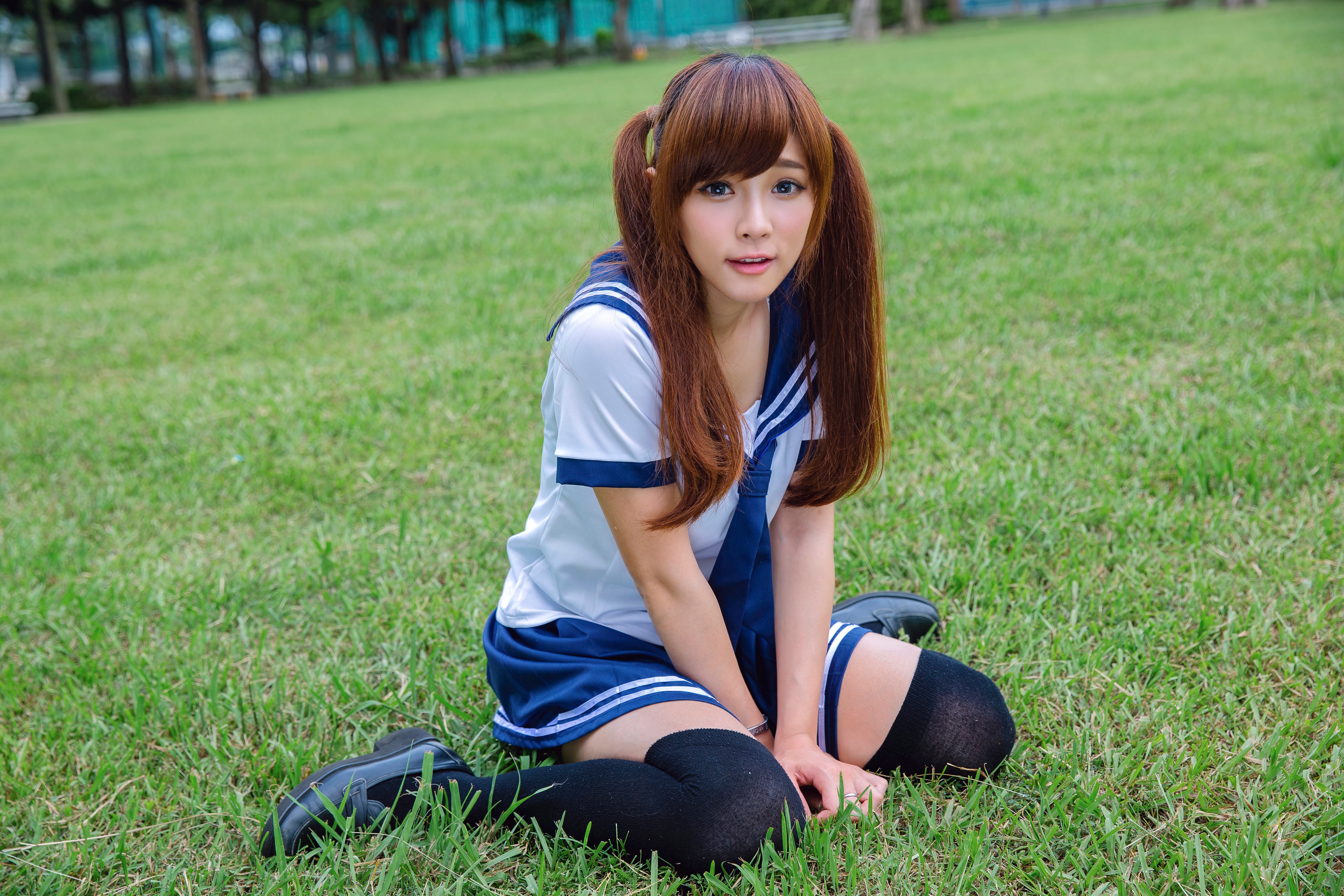 Asian girl in uniform sitting on grass HD Wallpaper