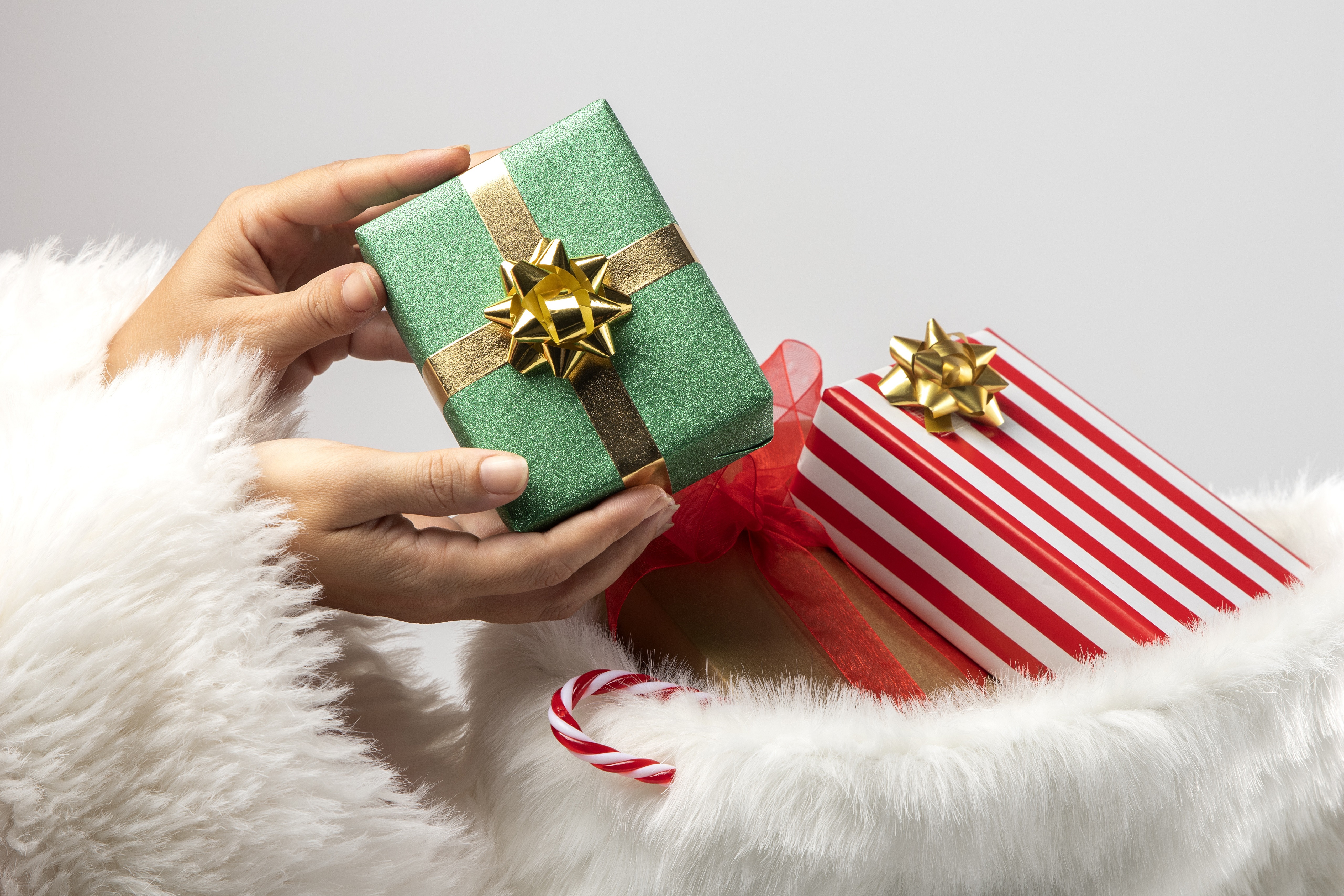 Hands holding Christmas gifts in a stocking HD Wallpaper