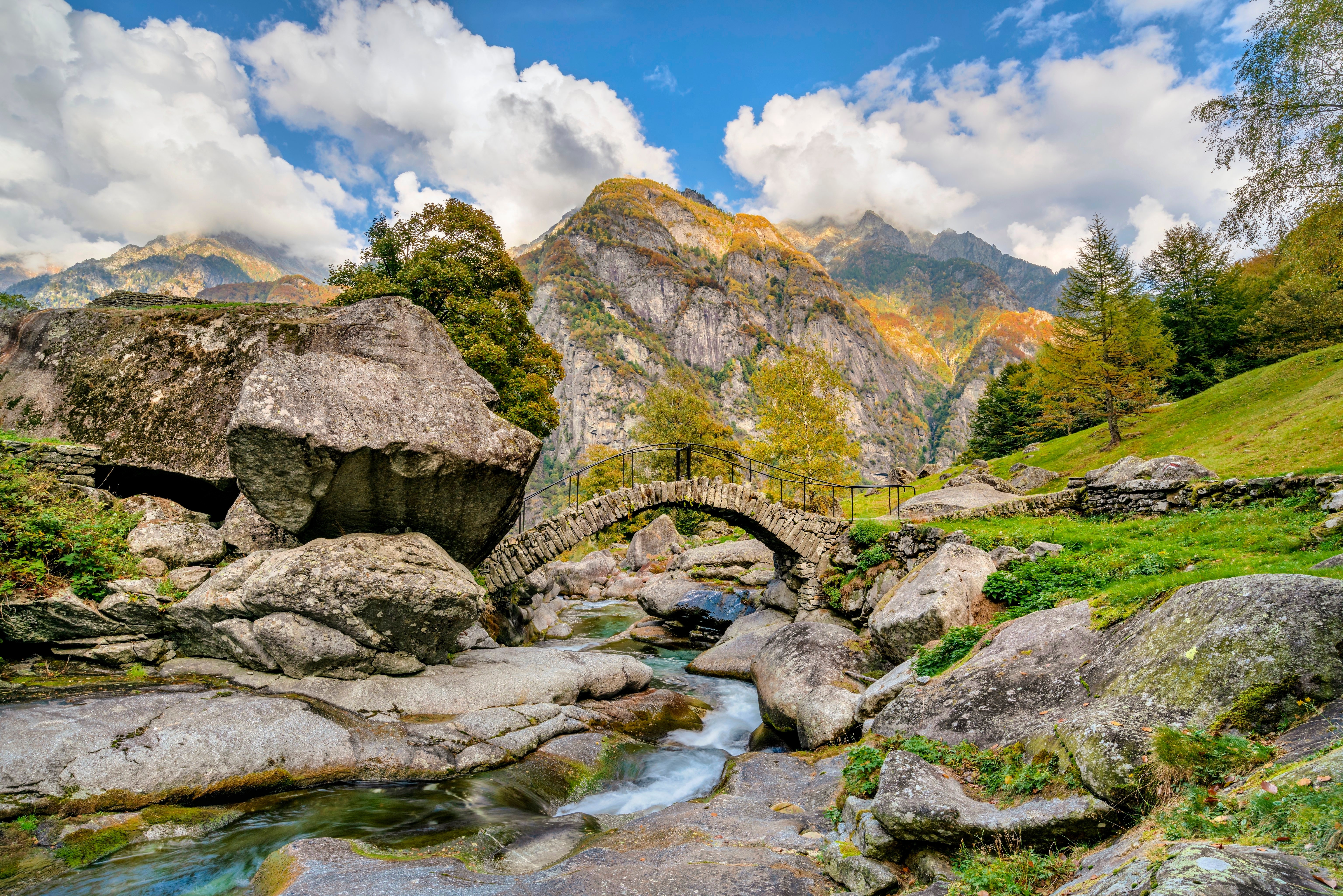 Stone bridge over a stream in the Swiss Alps HD Wallpaper