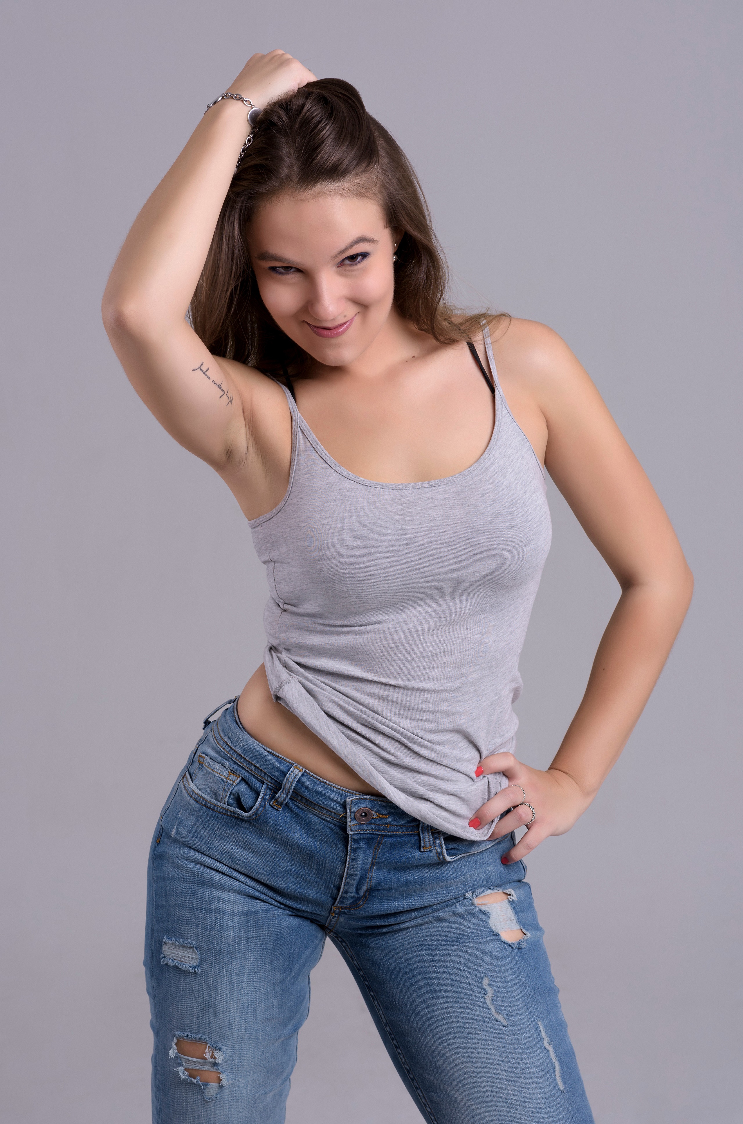 Woman in tank top and jeans posing HD Phone Wallpaper