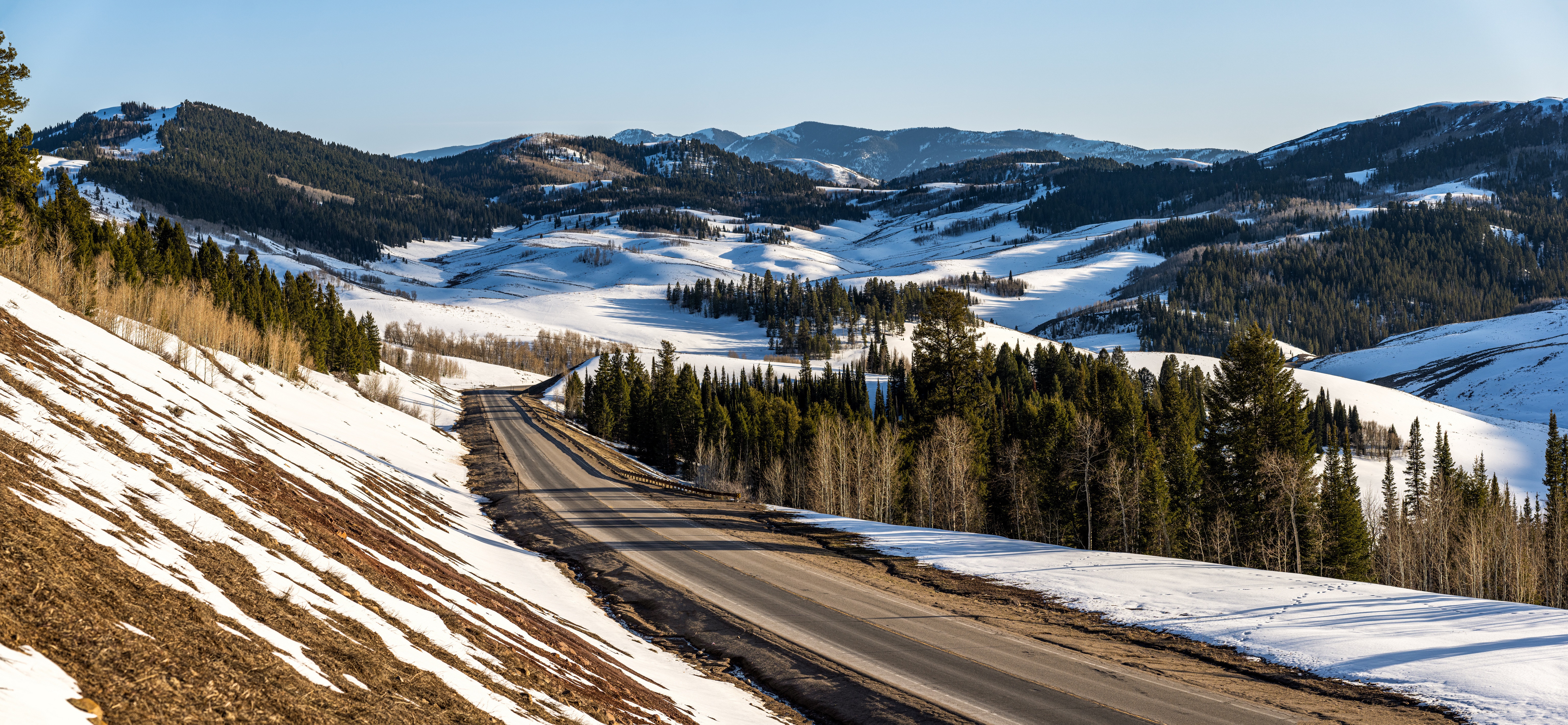 Road through snowy mountains in Wyoming, USA HD Wallpaper