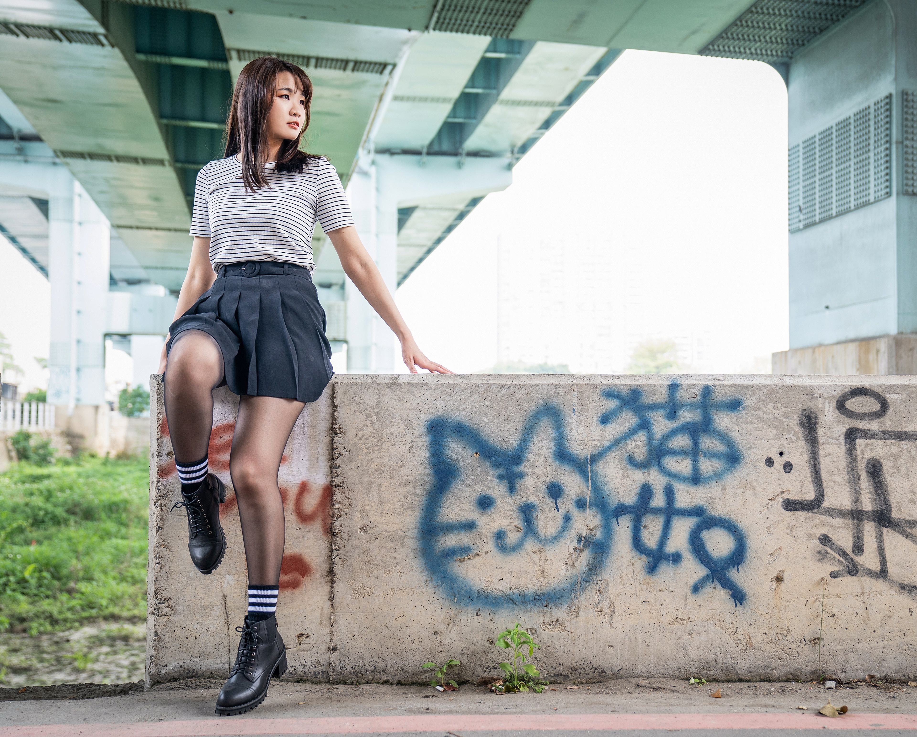 Asian girl in skirt and boots under bridge HD Wallpaper