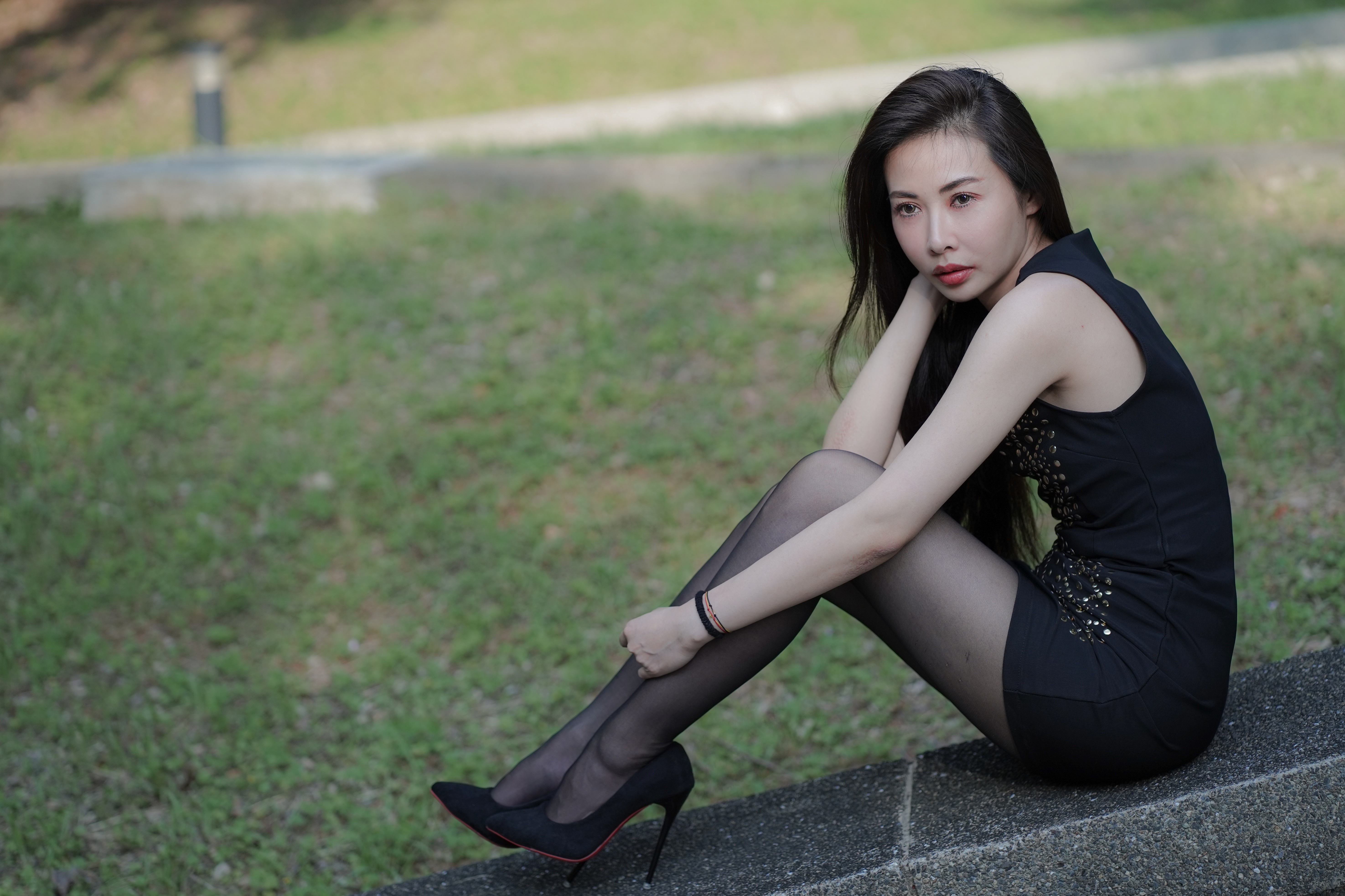 Asian woman in black dress and pantyhose sitting HD Wallpaper