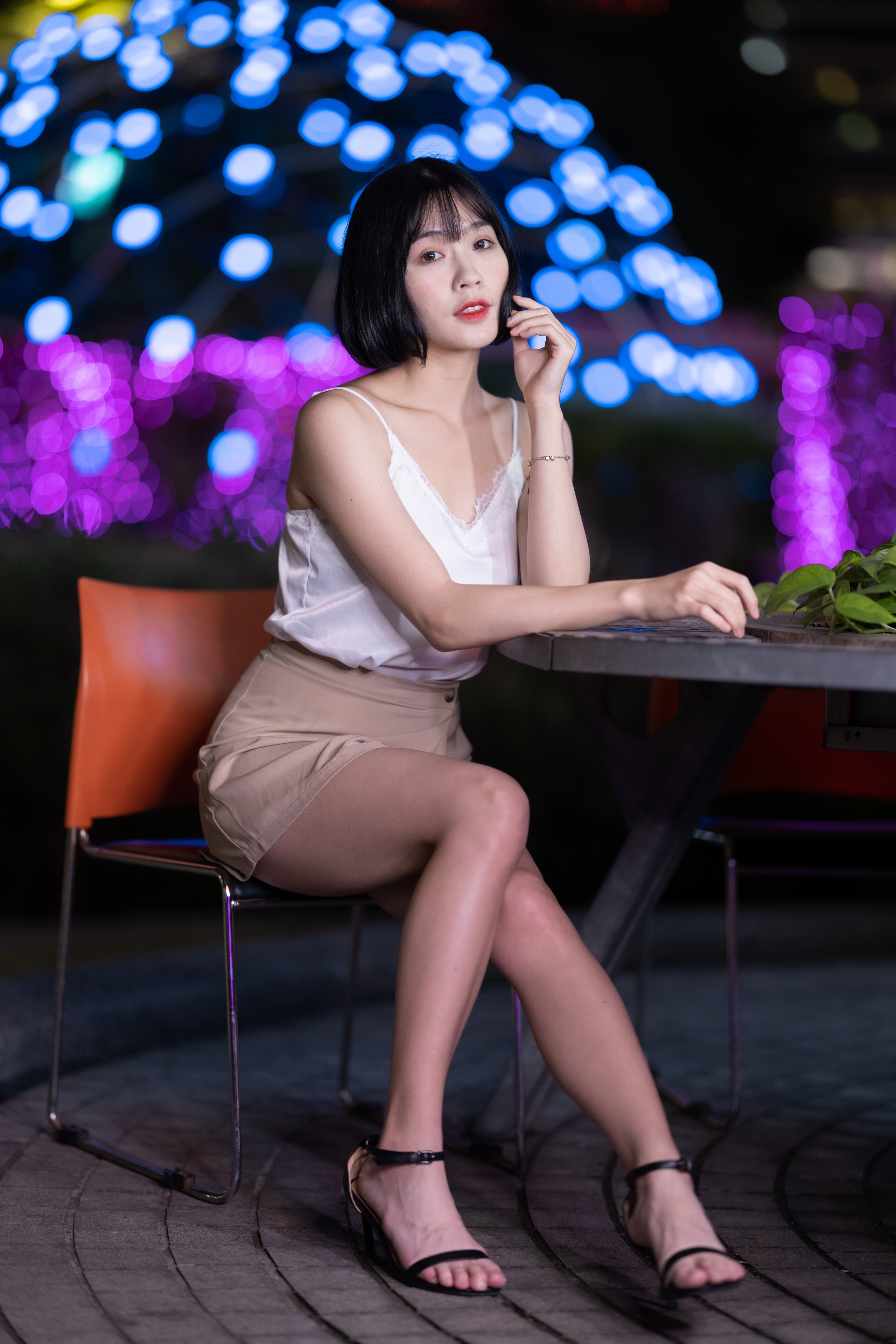 Brunette girl sitting at a table with bokeh lights HD Phone Wallpaper