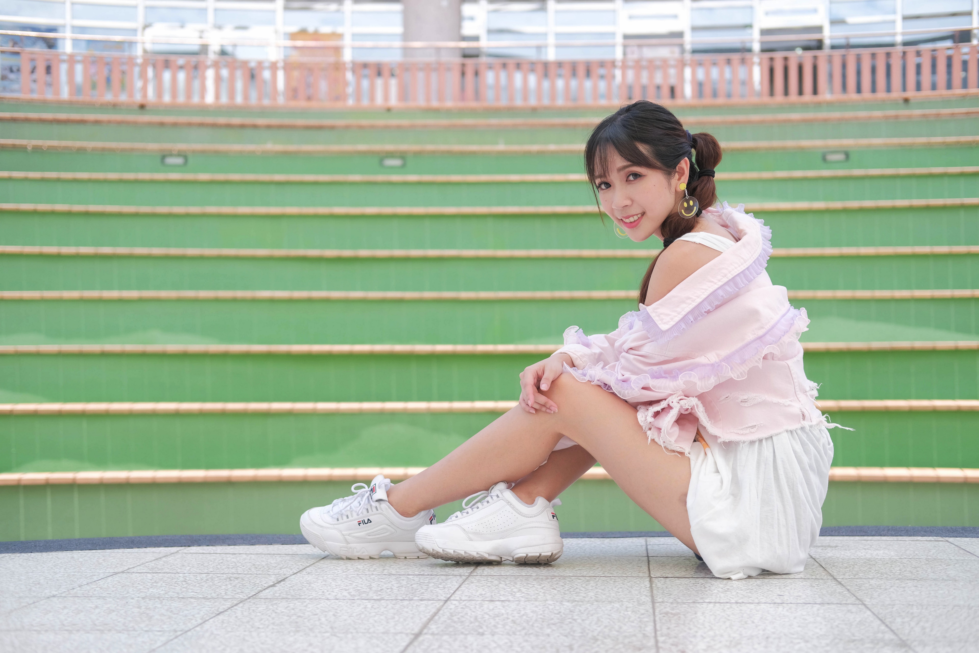 Asian woman sitting on steps wearing athletic shoes HD Wallpaper