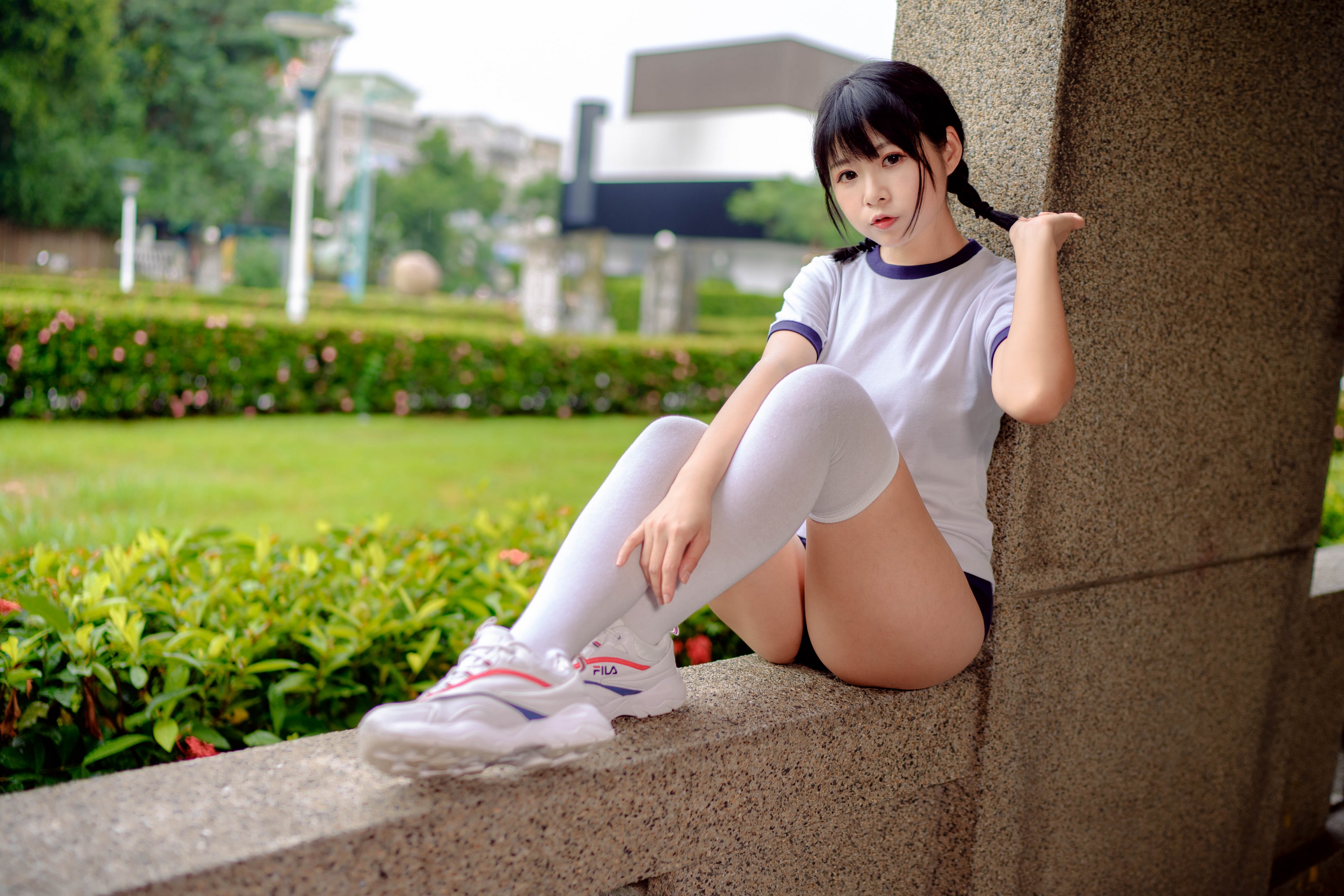 Brunette girl in athletic wear sitting outdoors HD Wallpaper