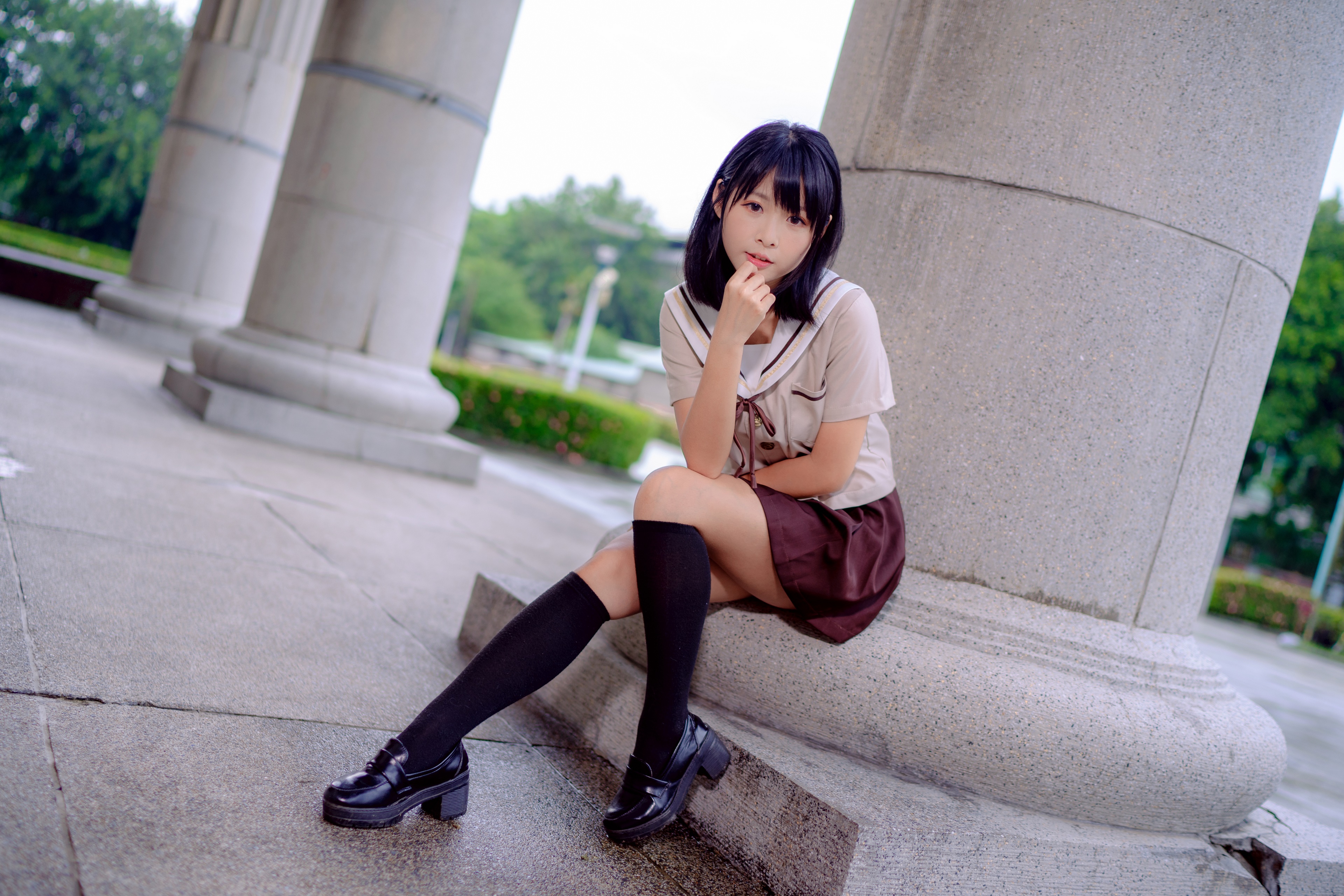 Brunette girl sitting by columns HD Wallpaper