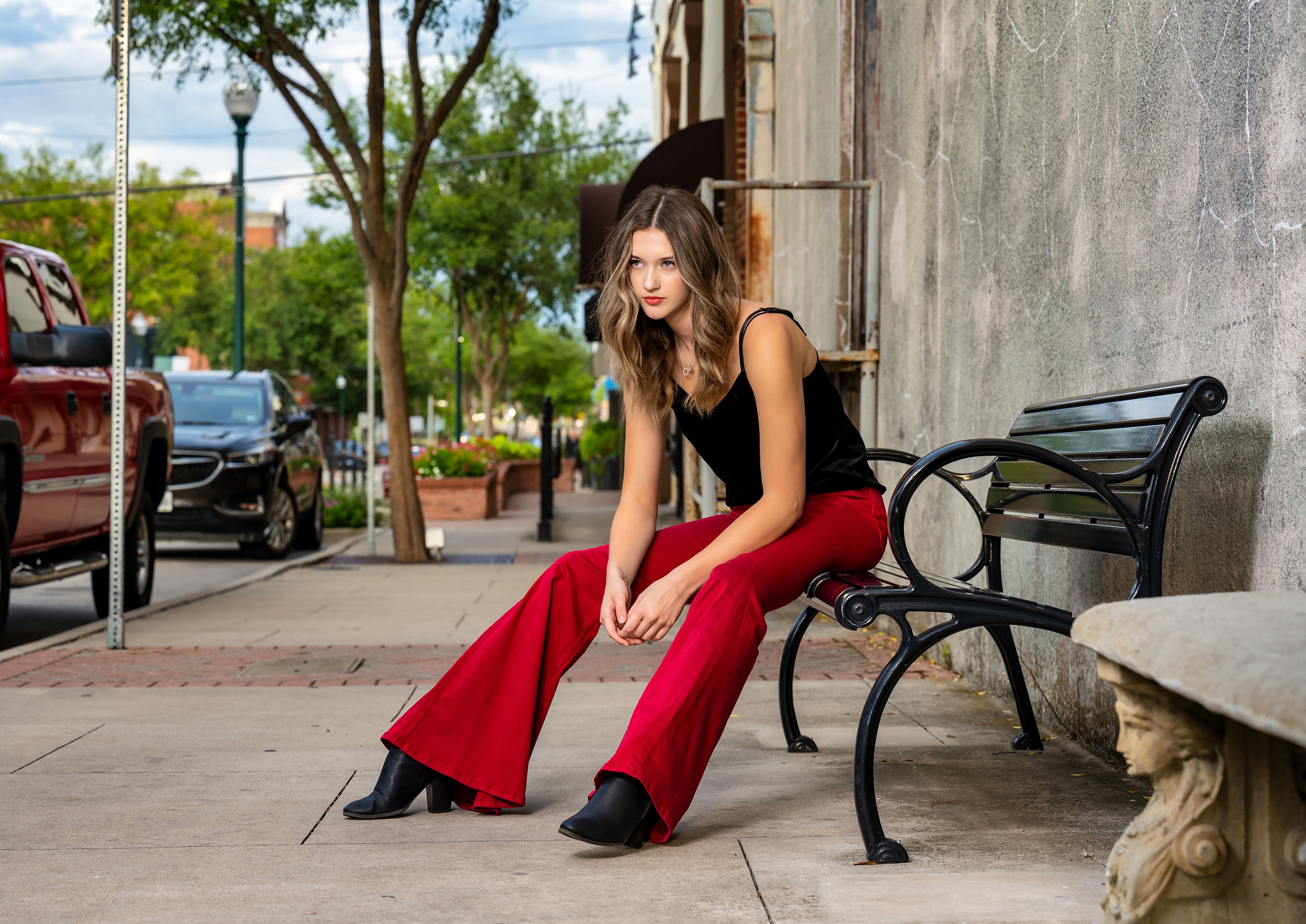 Ashley sitting on a bench wearing trousers HD Wallpaper