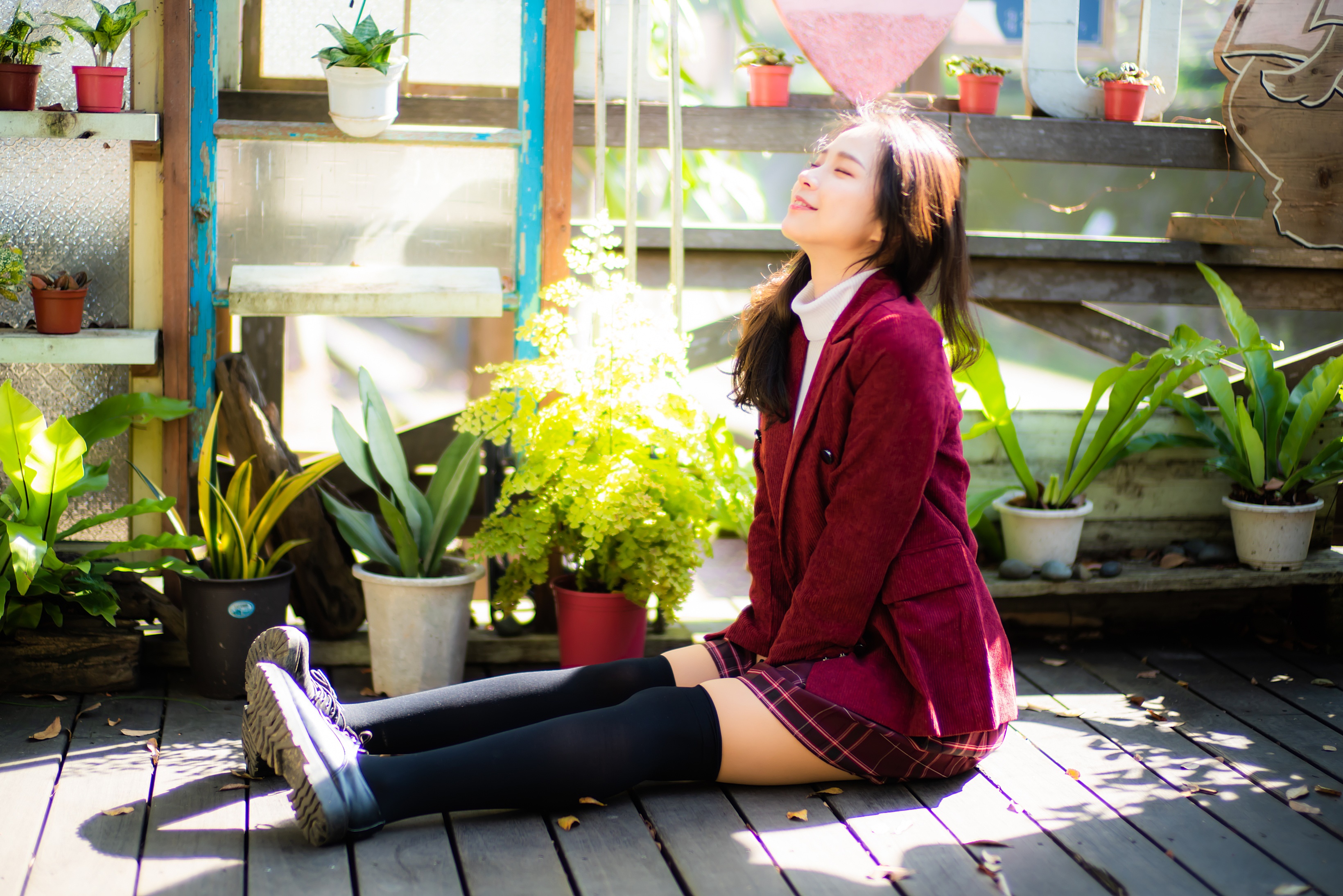 Asian woman in suit jacket and skirt sitting outdoors HD Wallpaper