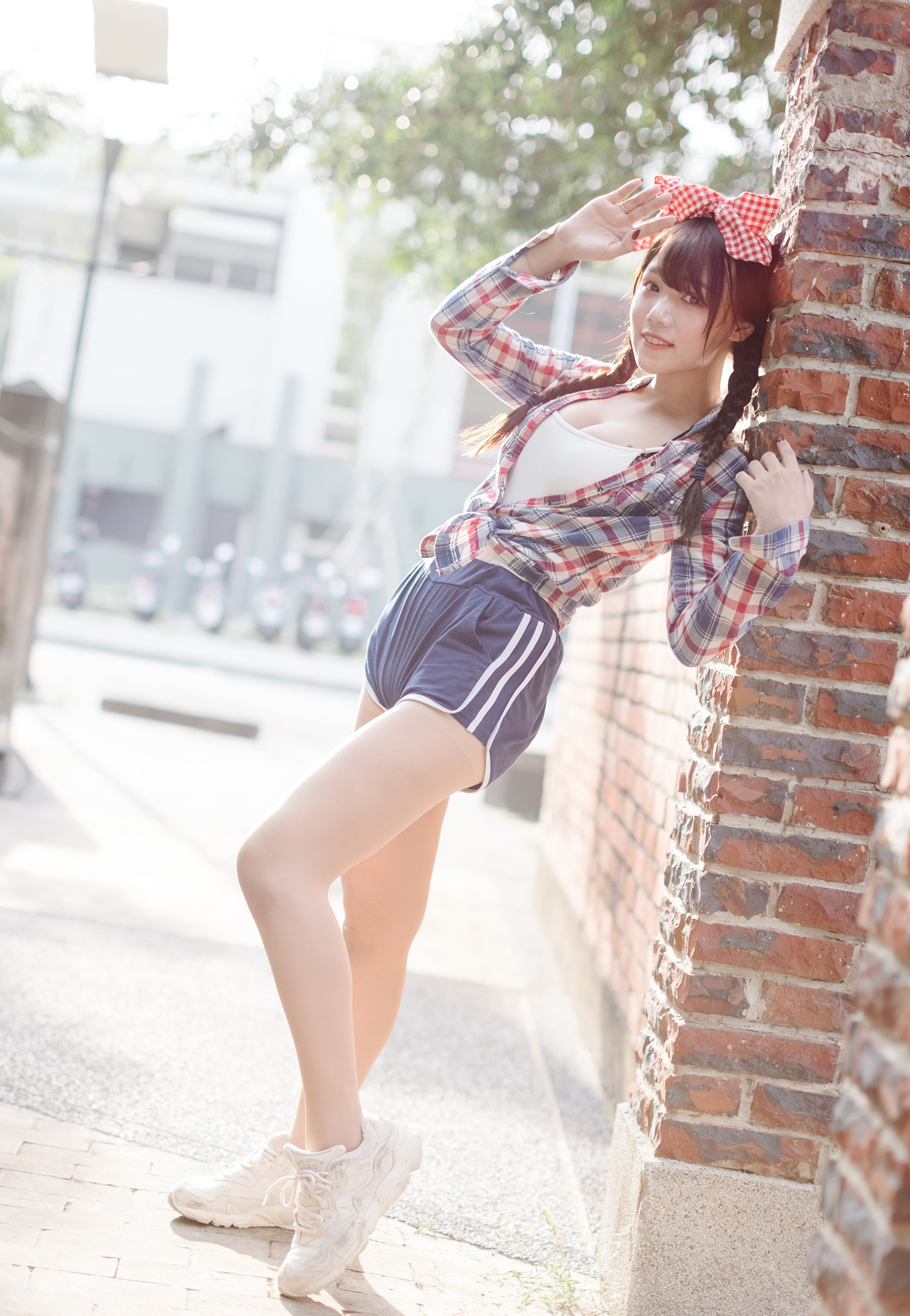 Asian girl with pigtails and plaid shirt leaning on brick wall HD Phone Wallpaper