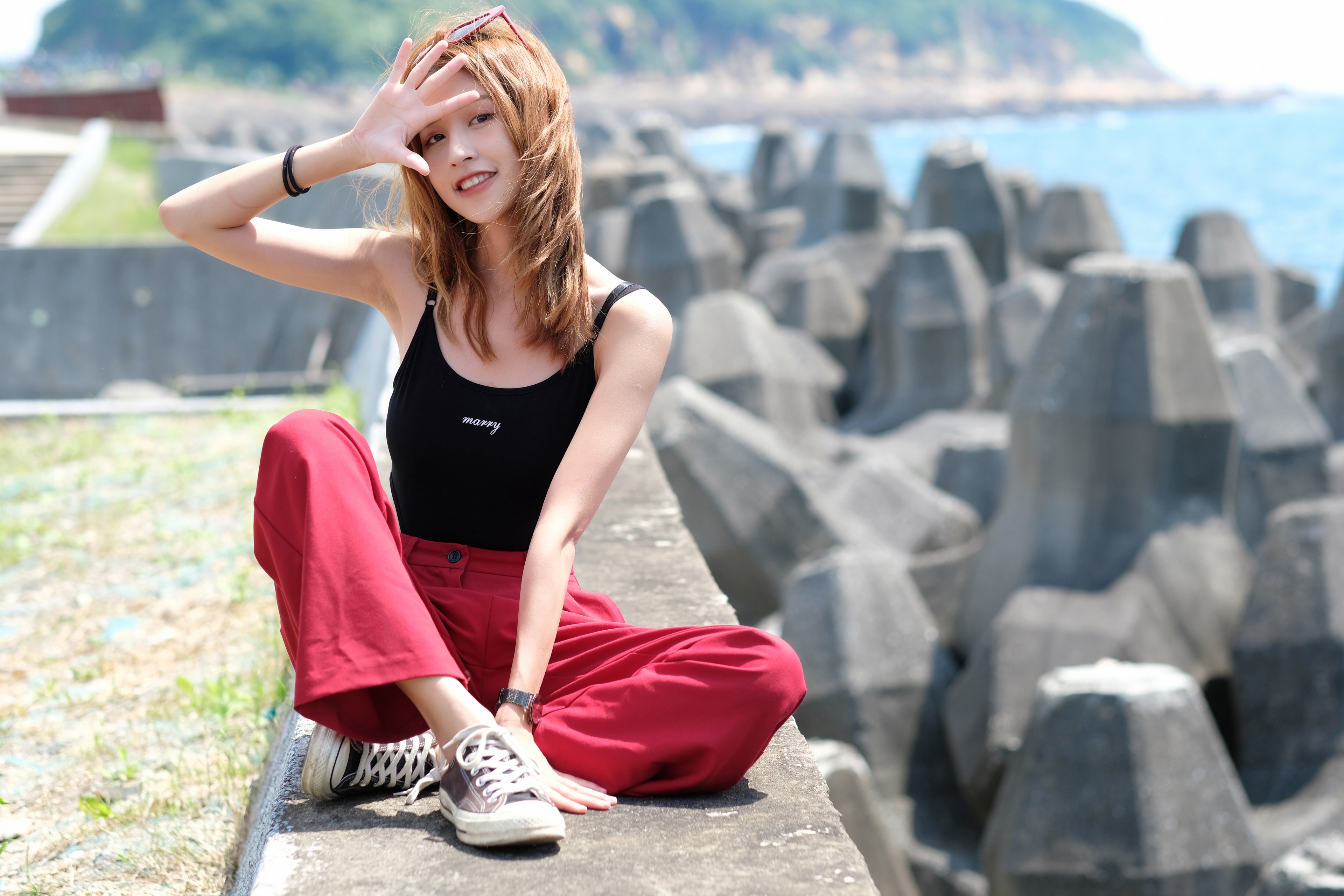 Asian woman sitting on a wall by the sea HD Wallpaper