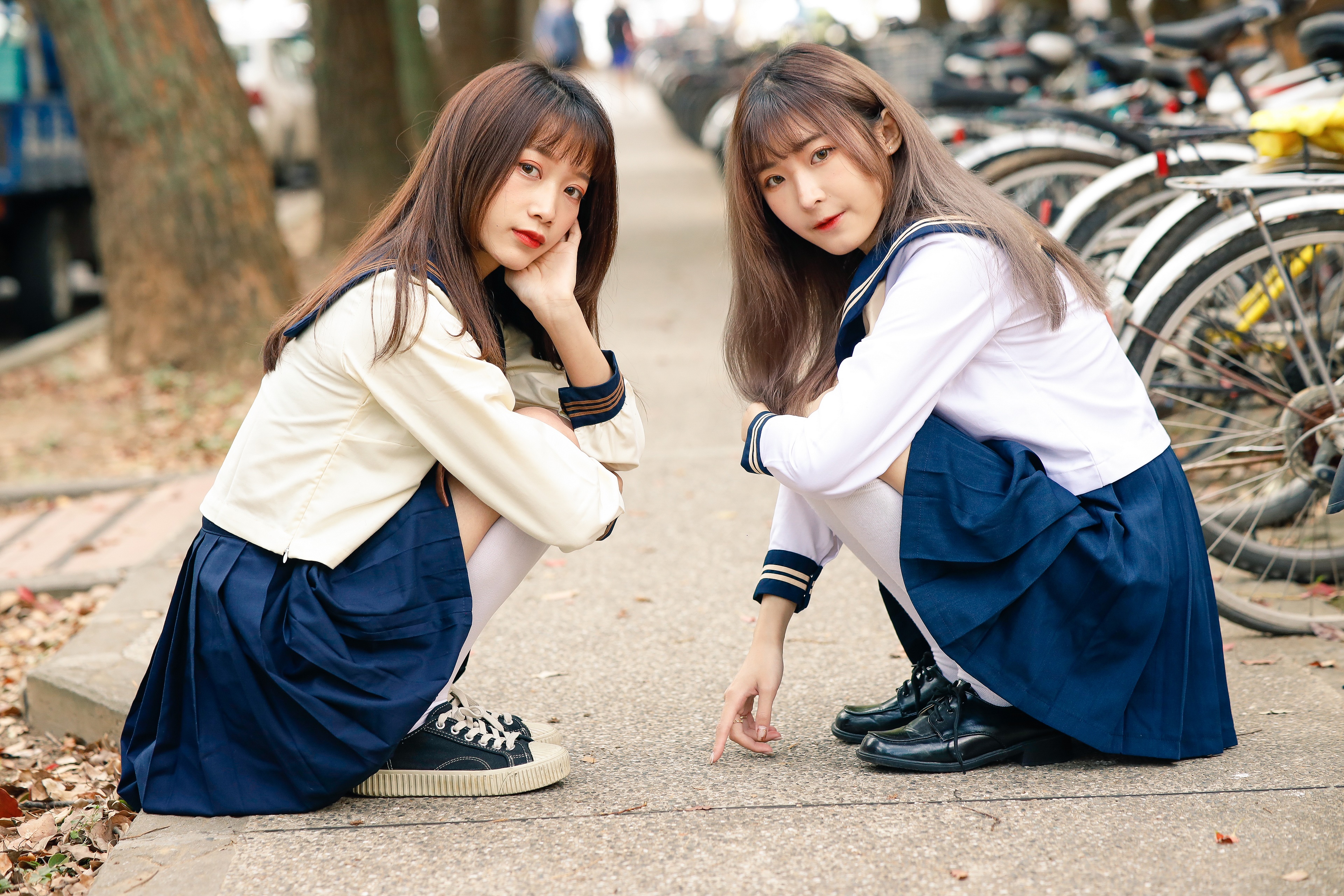 Two Asian schoolgirls sitting outdoors HD Wallpaper