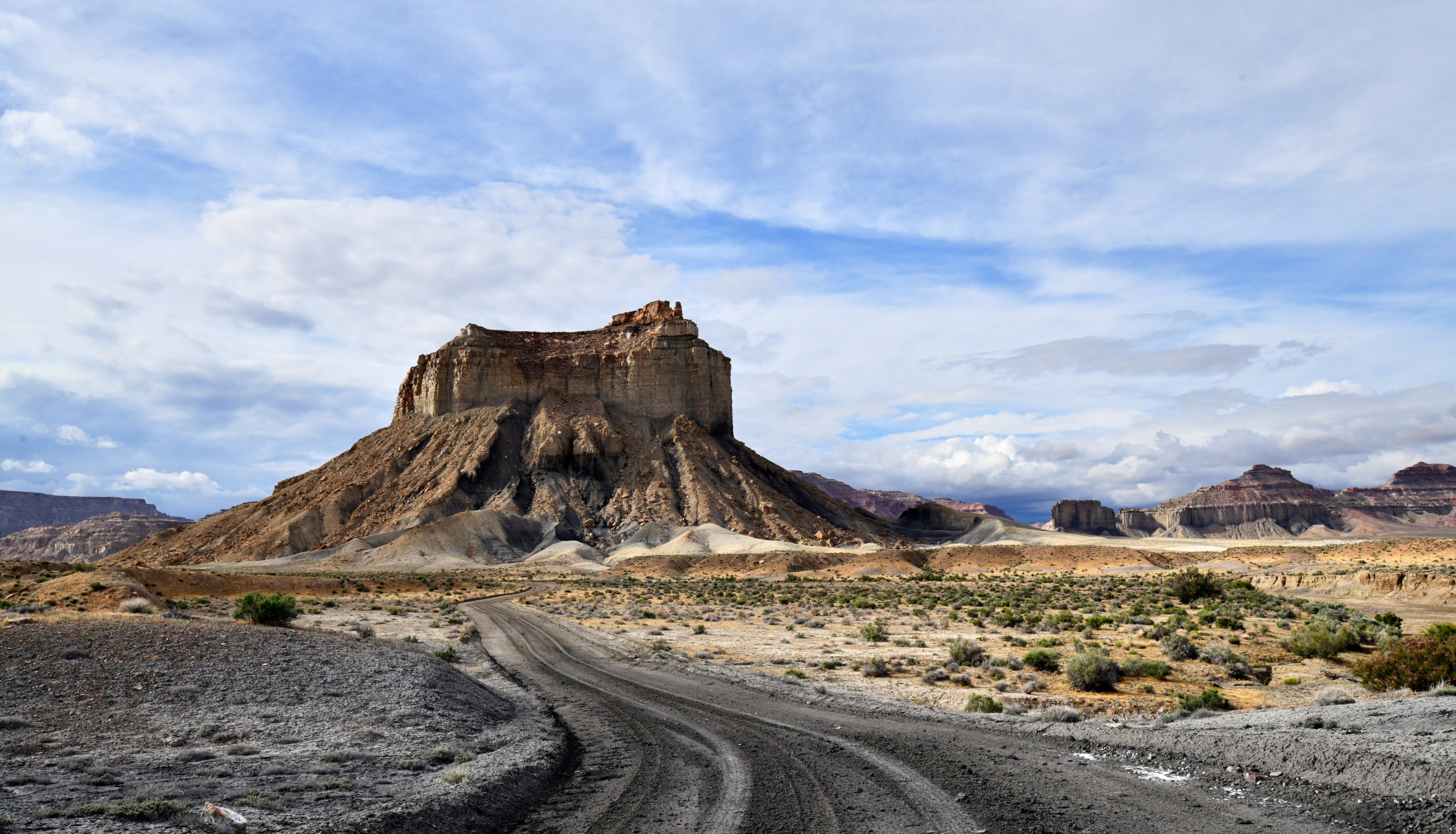 Dirt Road Leading to a Large Rock Formation in Utah HD Wallpaper