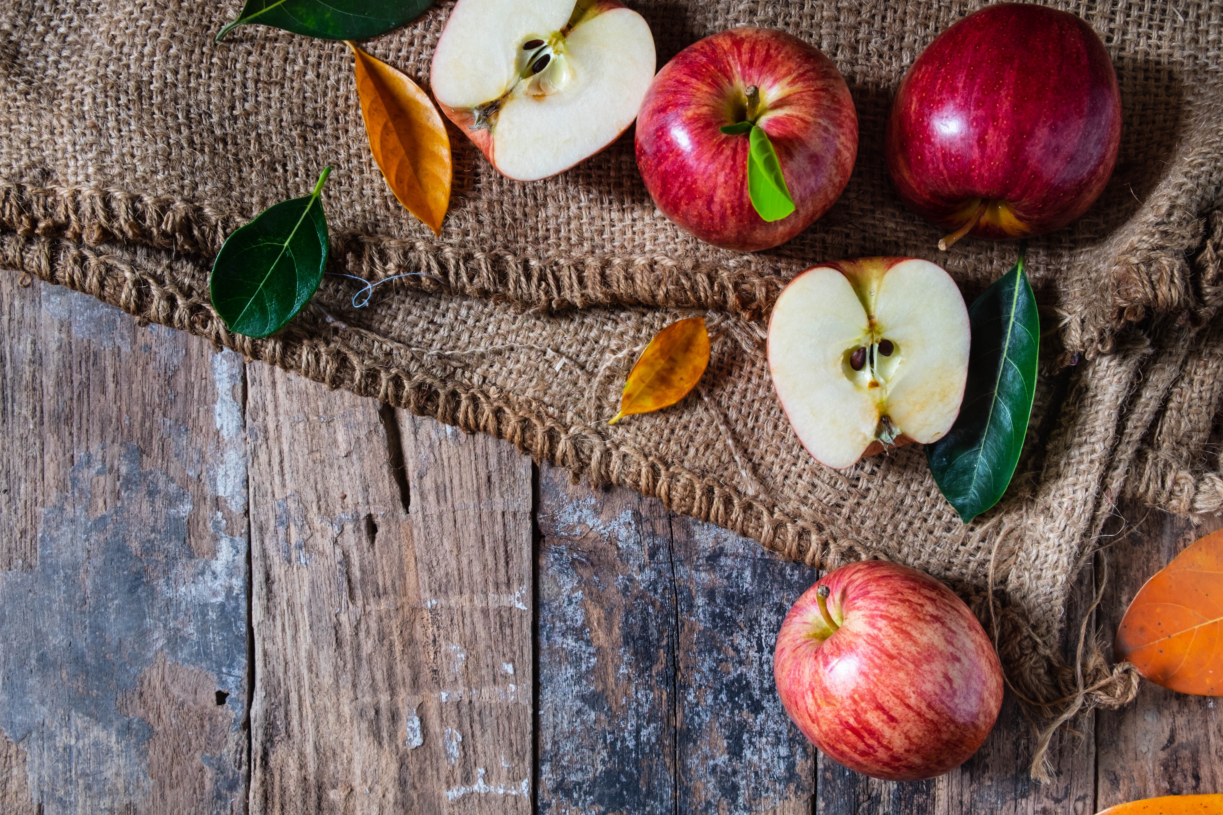 Apples and autumn leaves on burlap and wood HD Wallpaper