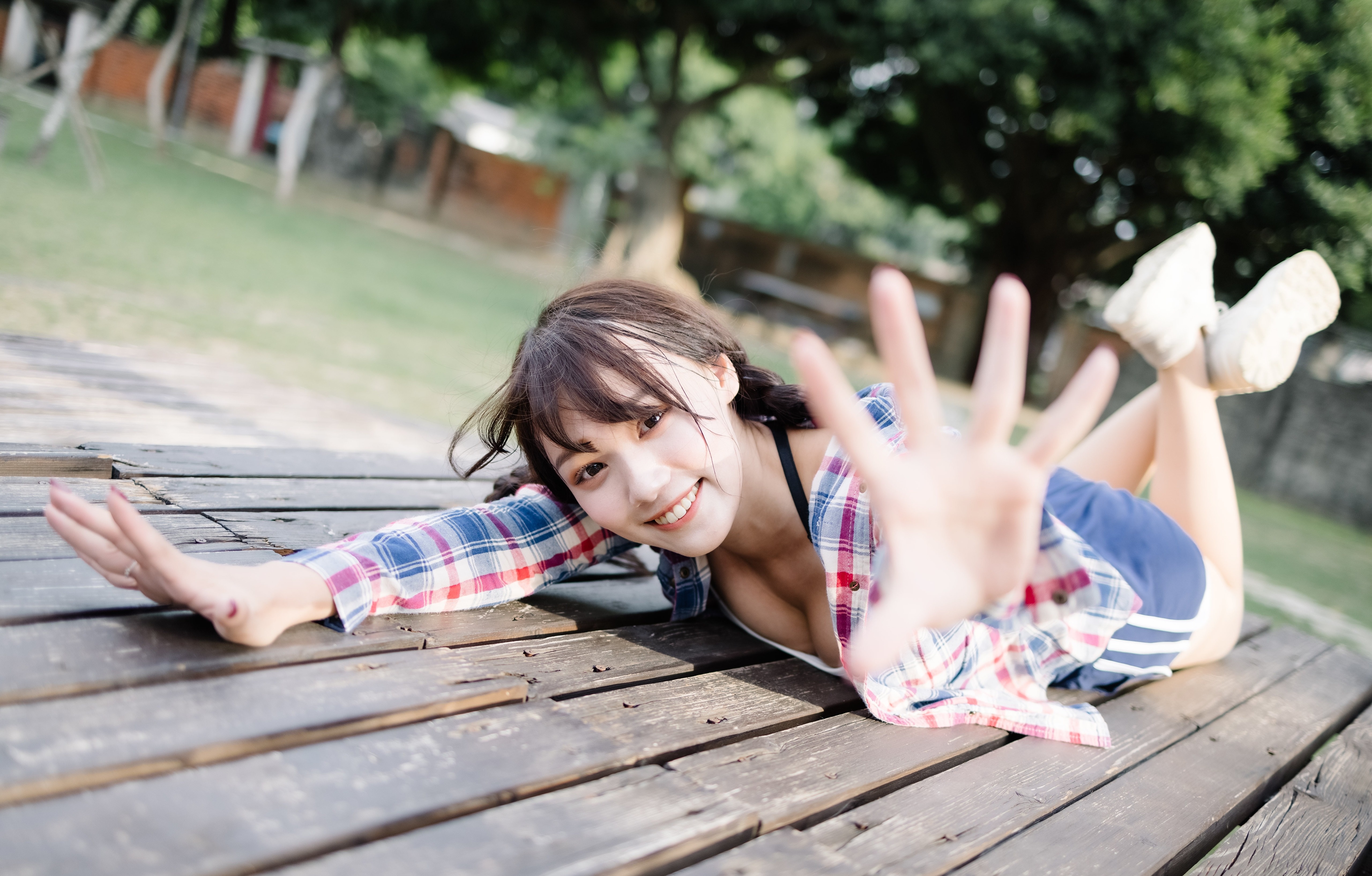 Asian girl lying on wooden planks, smiling HD Wallpaper