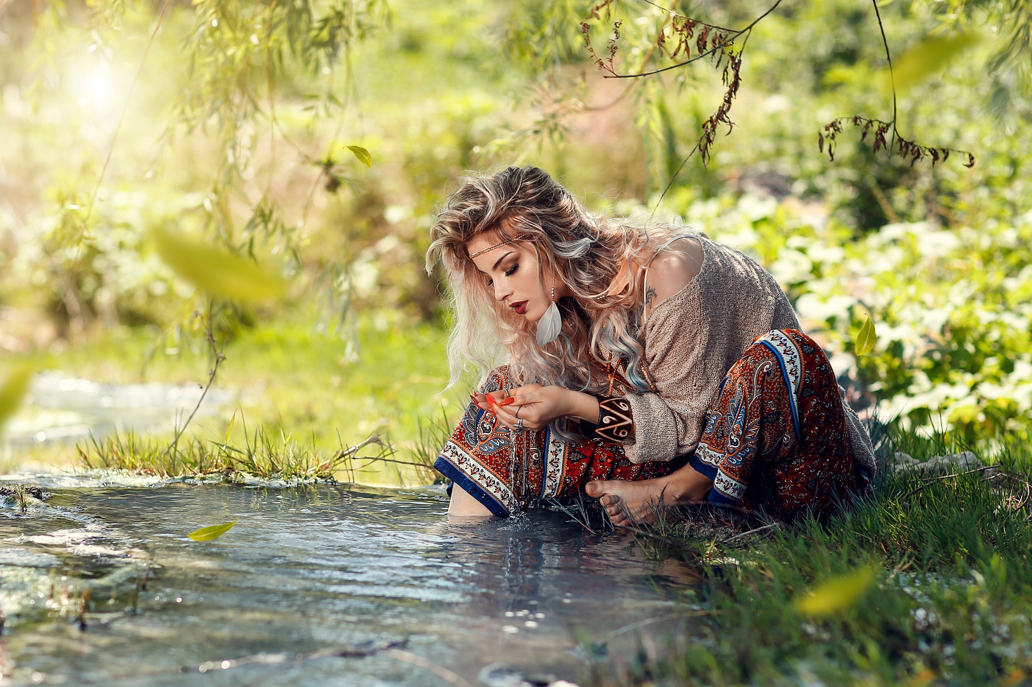 Woman sitting by a stream with leaves HD Wallpaper