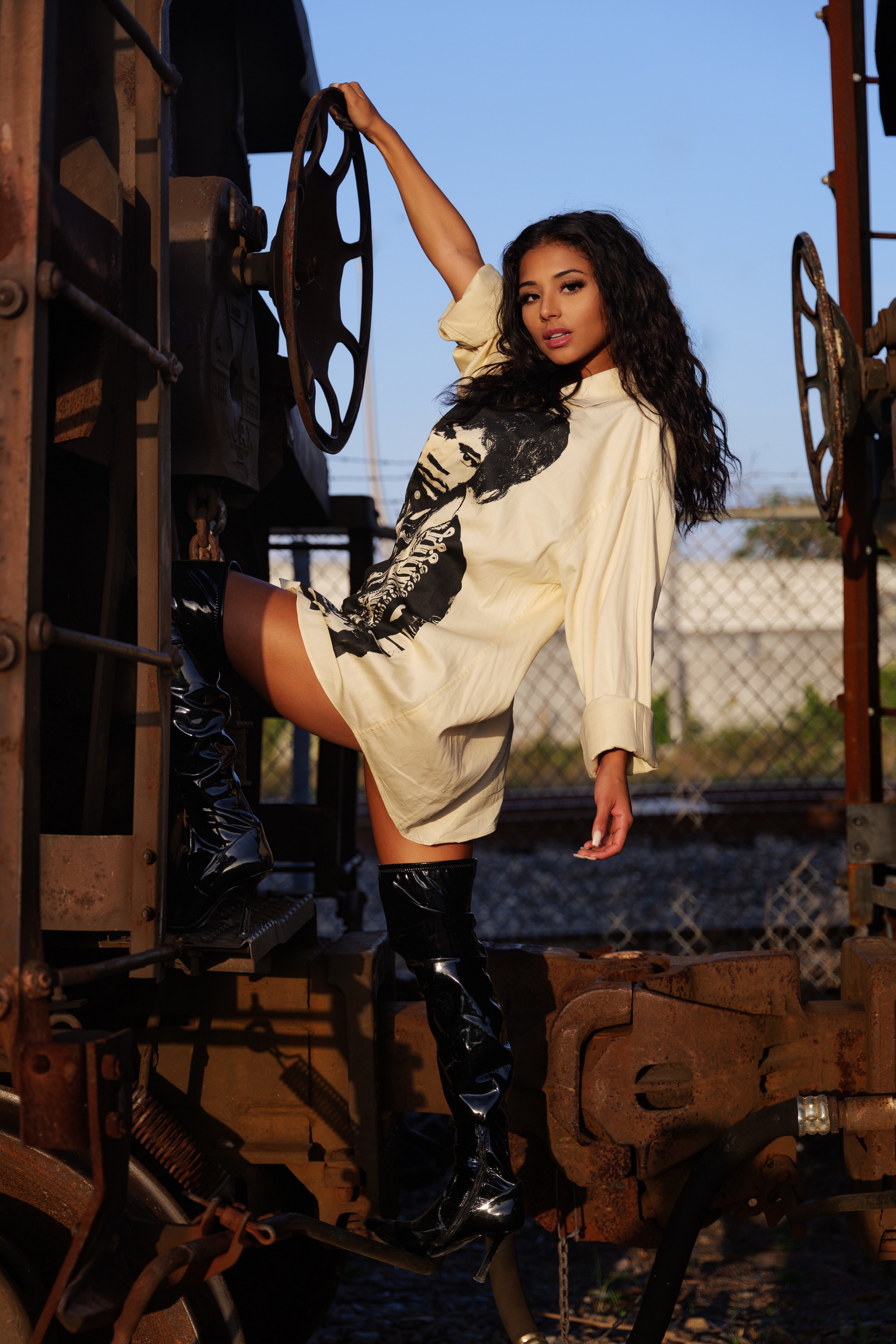 Woman in oversized shirt and thigh-high boots posing on train HD Phone Wallpaper