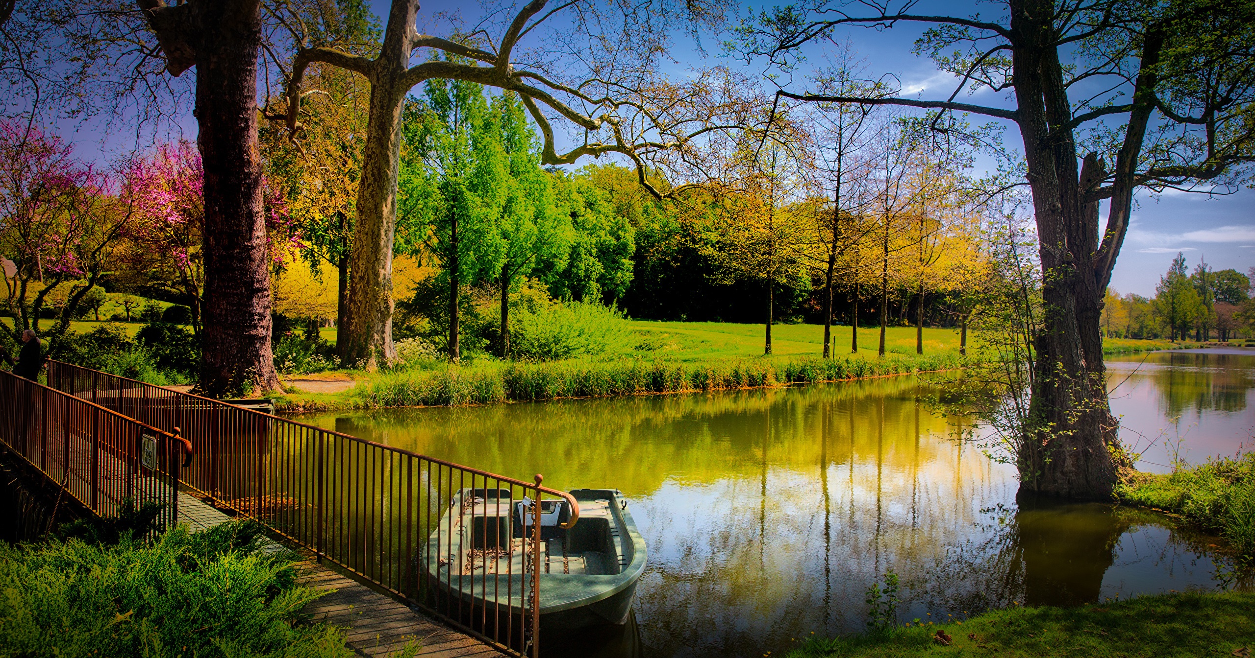 Park with a bridge, boat, and lake in Brissac-Quince, France HD Wallpaper