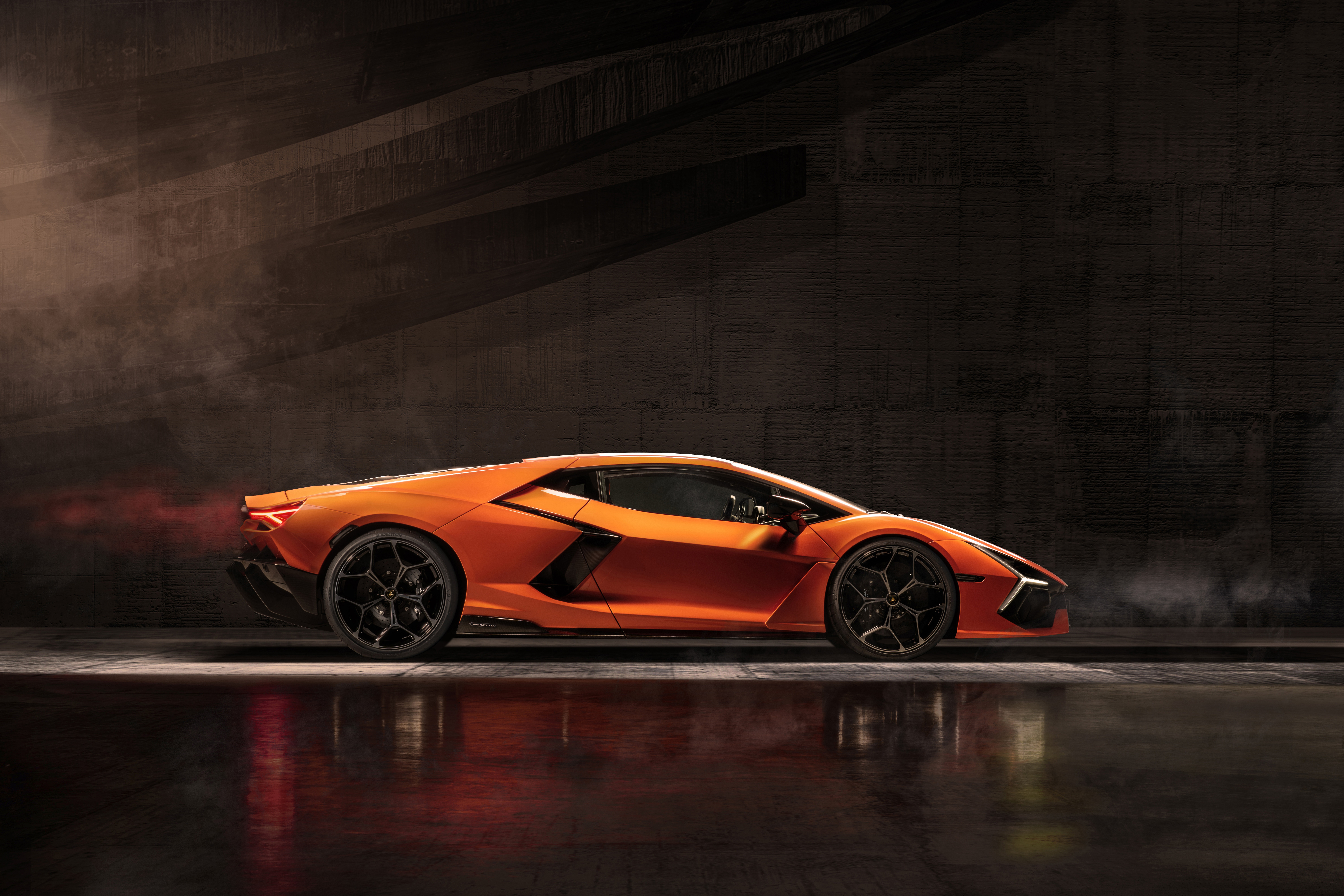 Orange Lamborghini Revuelto in a dark setting HD Wallpaper