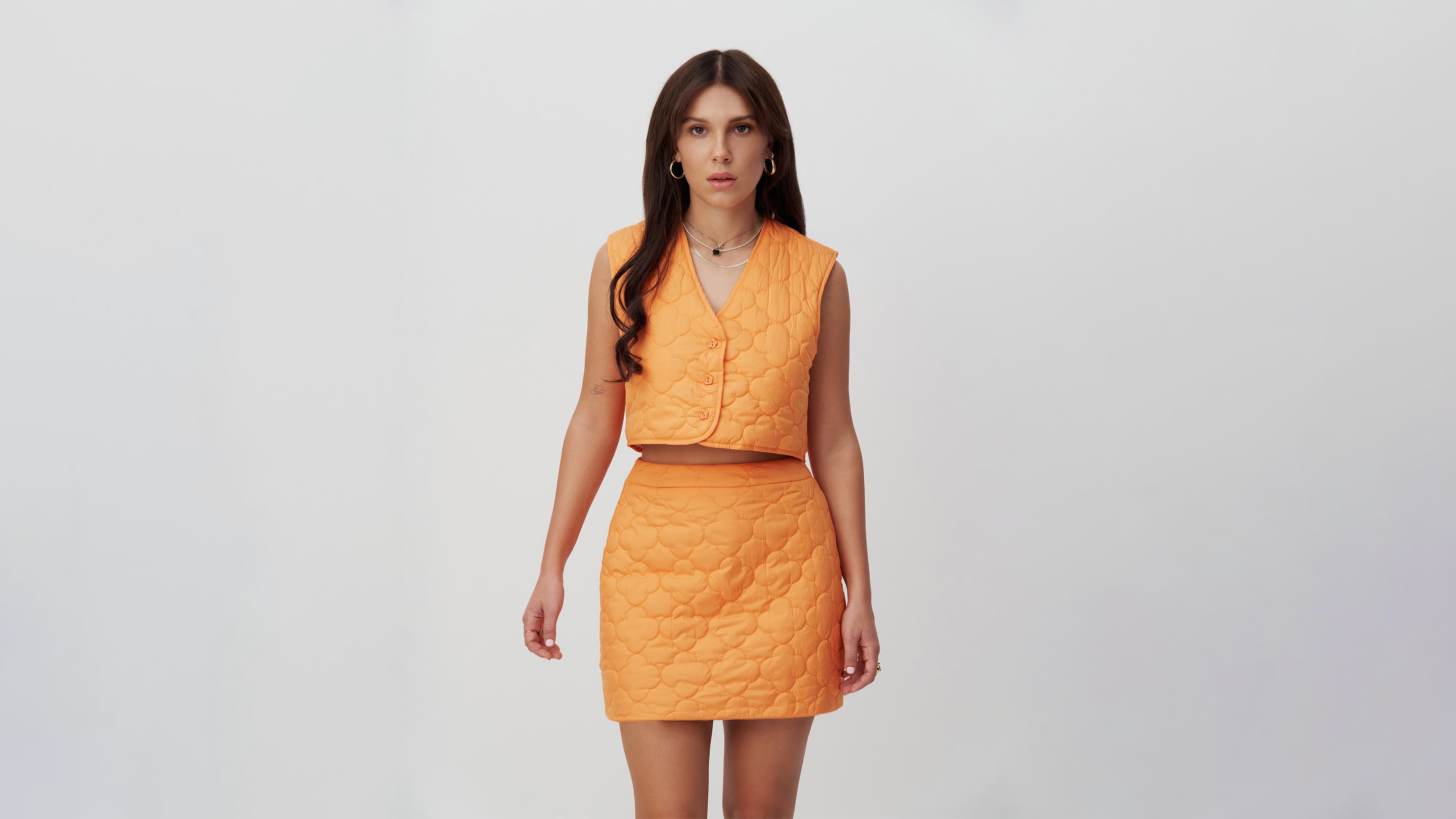 Woman in orange quilted vest and skirt HD Wallpaper