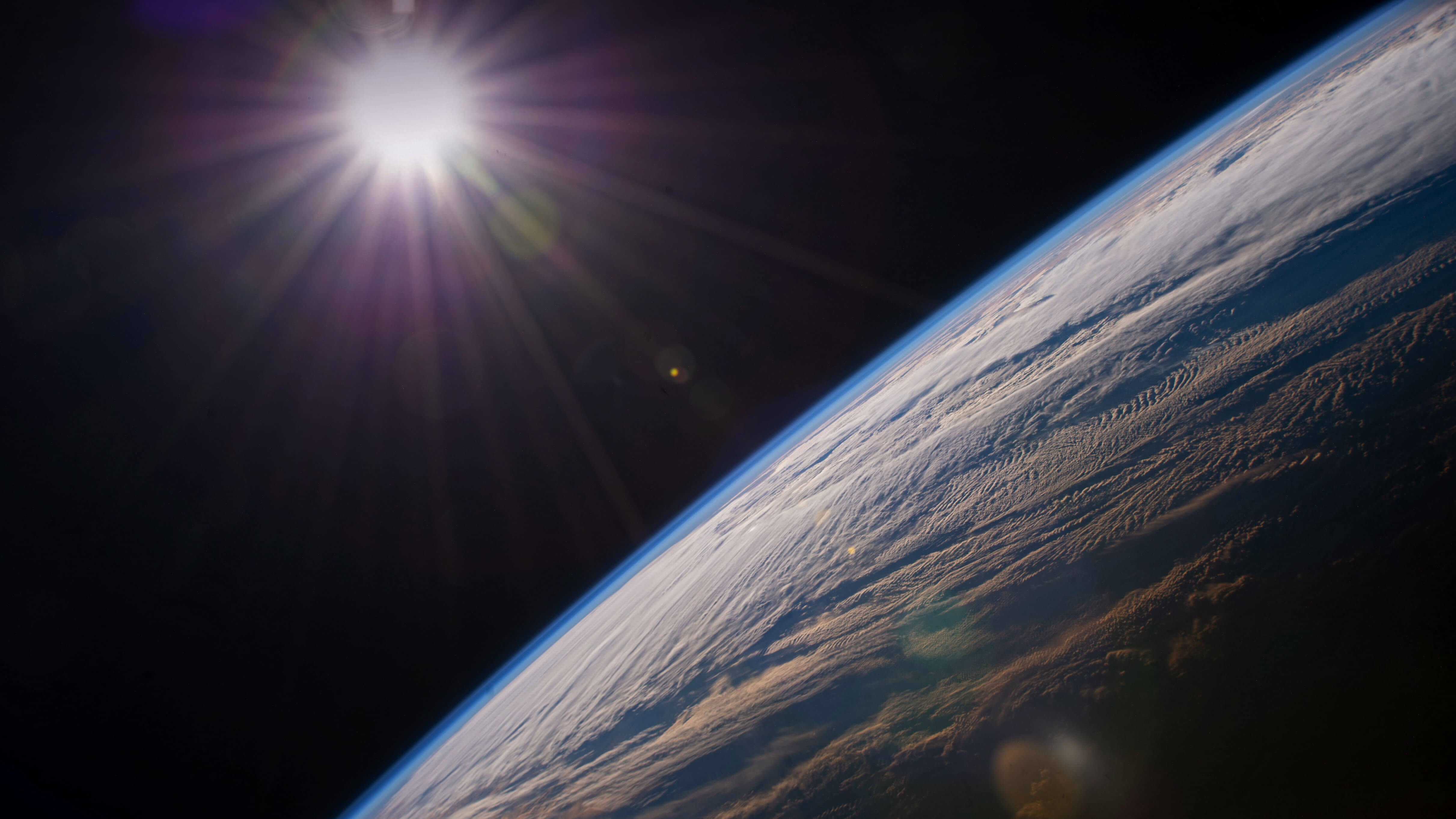 Earth from space with sun glare HD Wallpaper