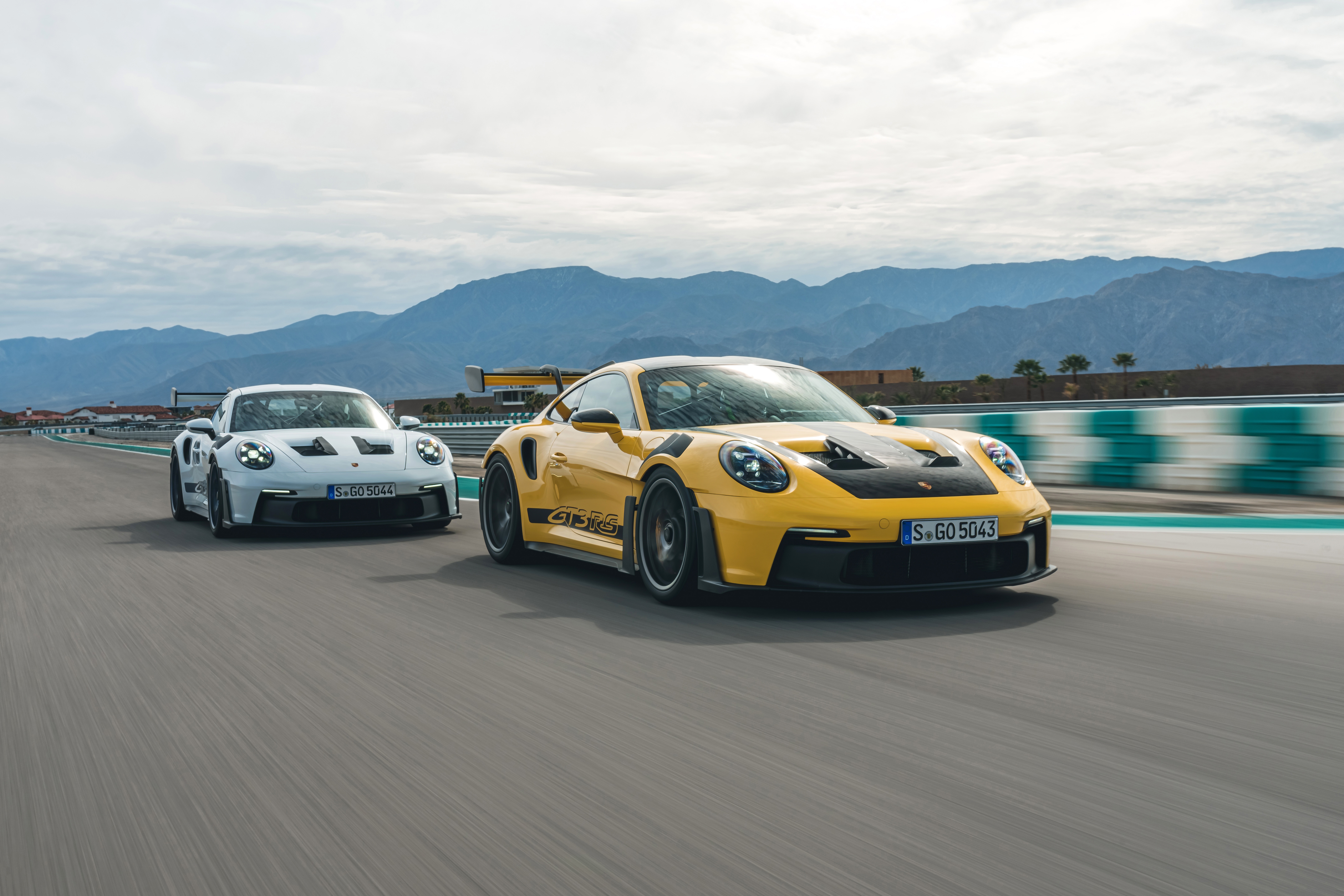 Two Porsche 911 GT3 RS cars on a racetrack HD Wallpaper