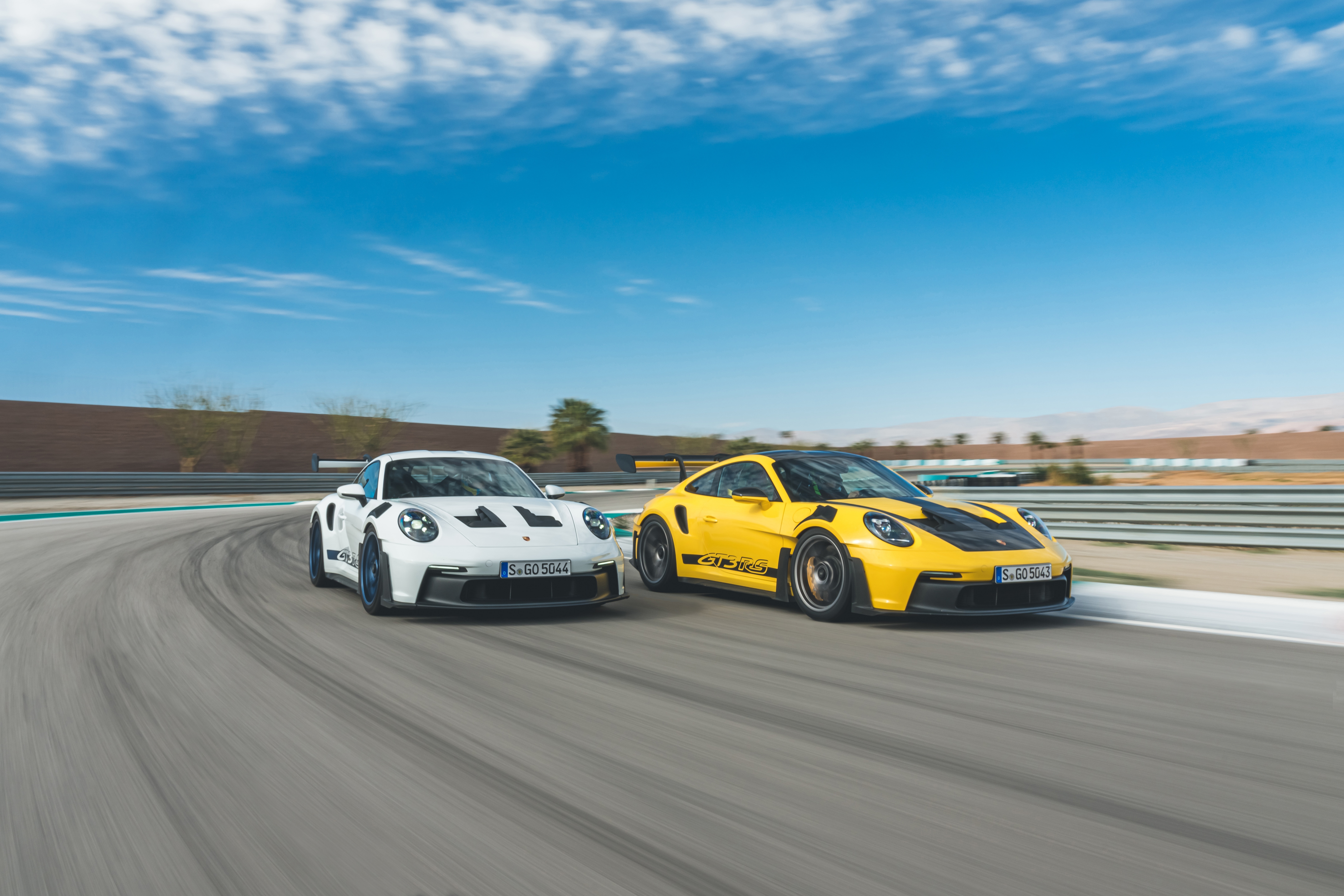 Two Porsche 911 GT3 RS cars on a racetrack HD Wallpaper
