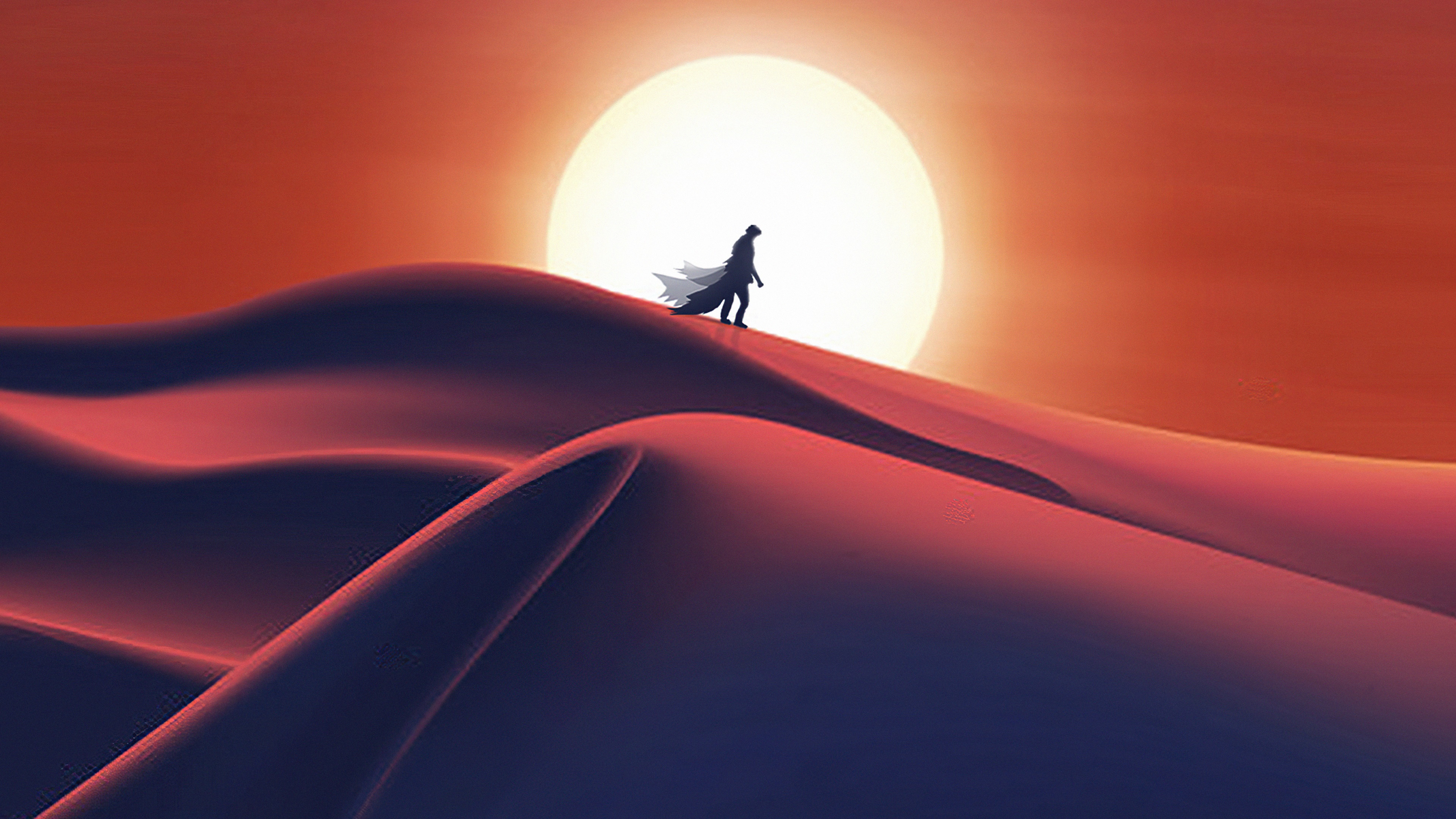 Man in cloak walking on desert dunes with sun HD Wallpaper