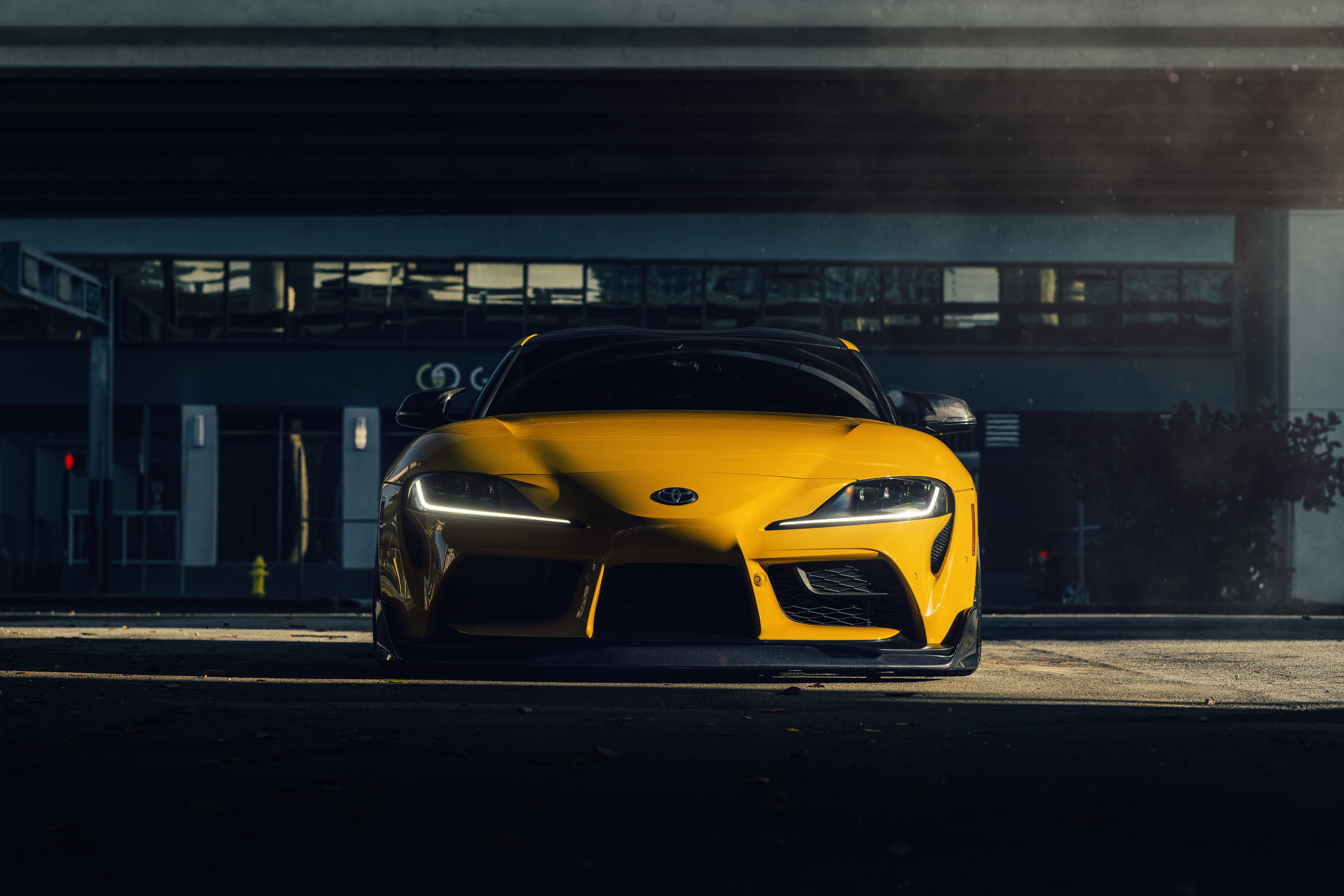 Yellow Toyota Supra parked under a bridge HD Wallpaper